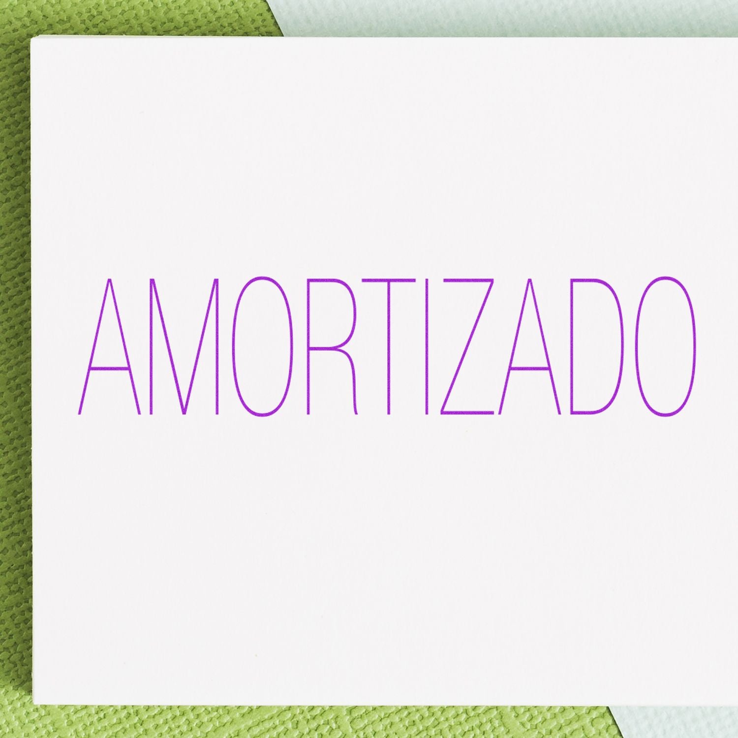 Self Inking Amortizado Stamp imprint on white paper with green textured background.