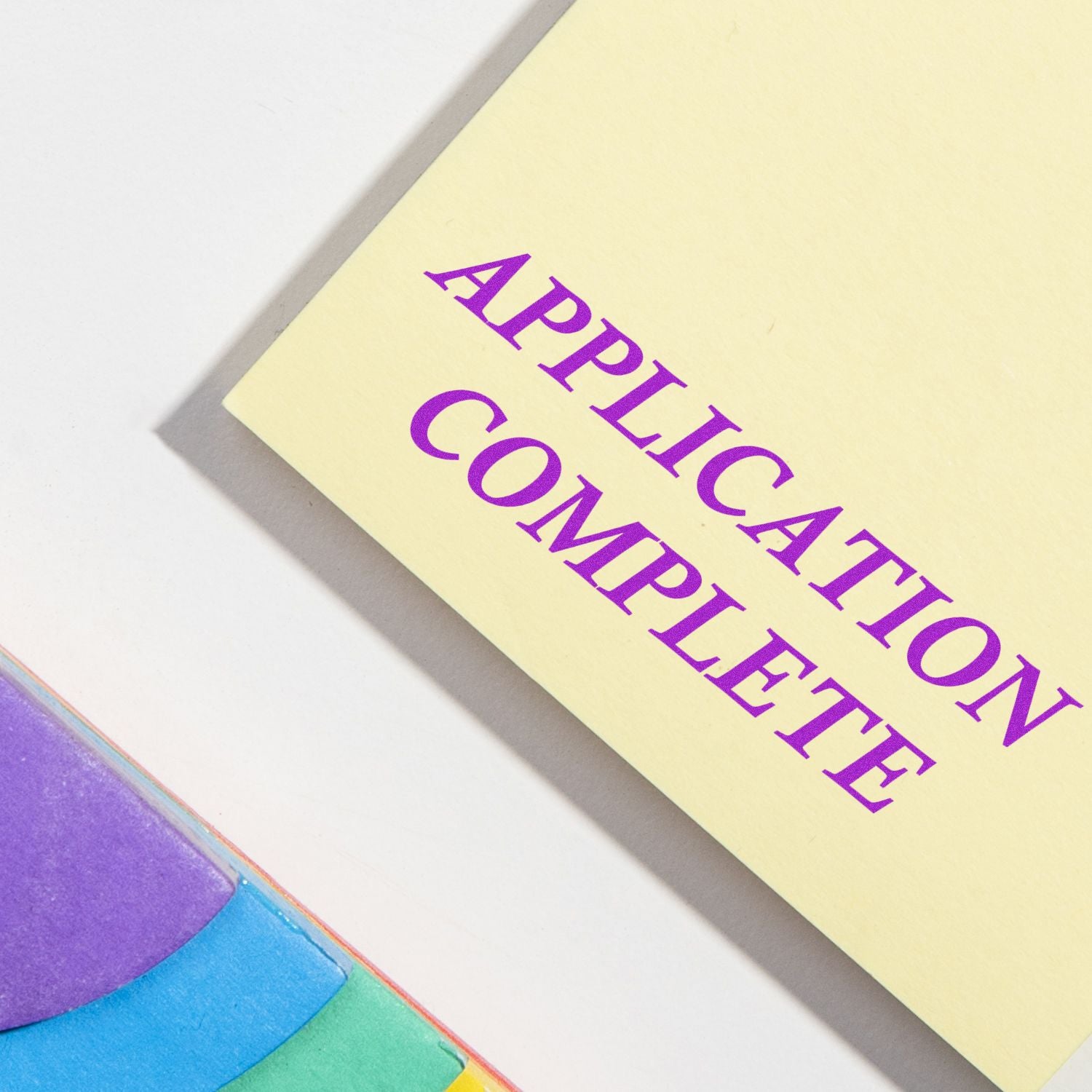 Document stamped with 'APPLICATION COMPLETE' using the Large Pre-Inked Application Complete Stamp, next to colorful sticky notes.