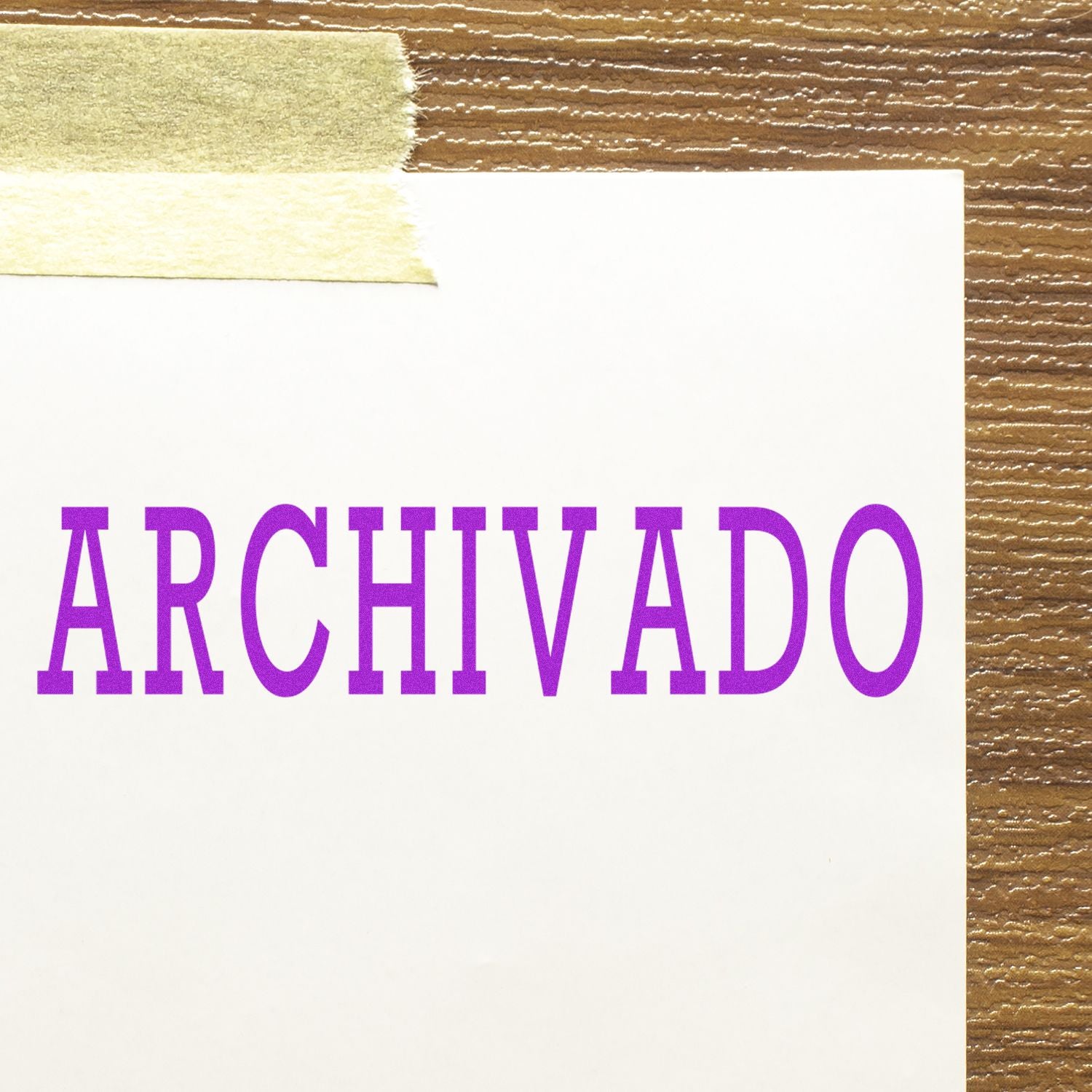 A white paper with the word ARCHIVADO stamped in purple ink using a Self Inking Archivado Stamp, taped to a wooden surface.