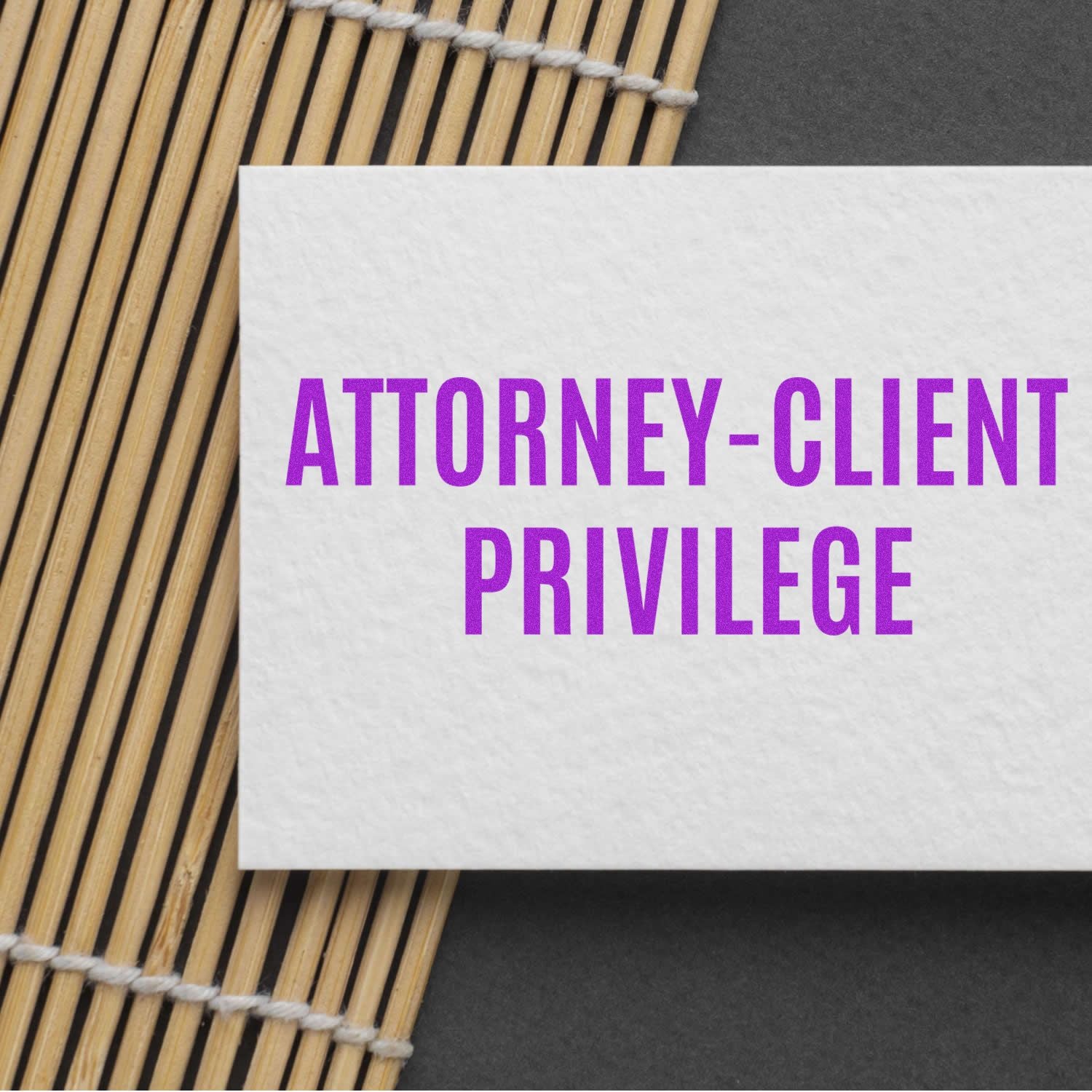 A white card stamped with ATTORNEY-CLIENT PRIVILEGE in purple ink using the Large Attorney-Client Privilege Rubber Stamp on a bamboo mat.