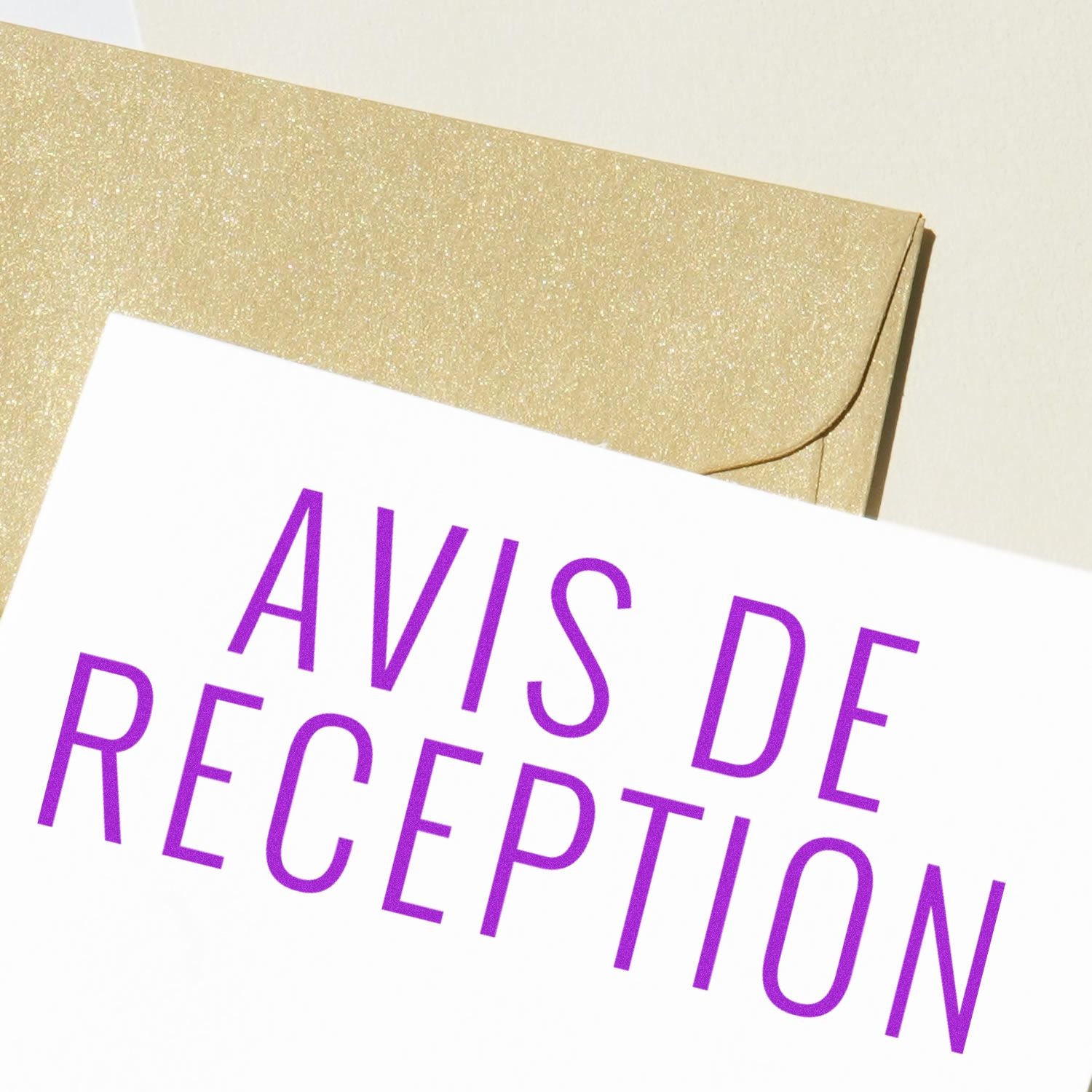 A white paper stamped with AVIS DE RECEPTION in purple ink using the Large Avis De Reception Rubber Stamp, next to a gold envelope.