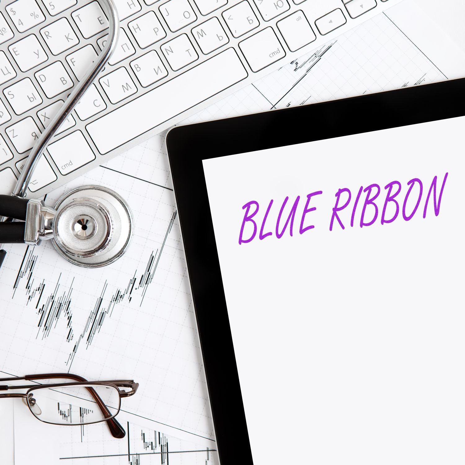 Large Pre-Inked Blue Ribbon Stamp in use on a desk with a keyboard, stethoscope, glasses, and tablet displaying BLUE RIBBON text.