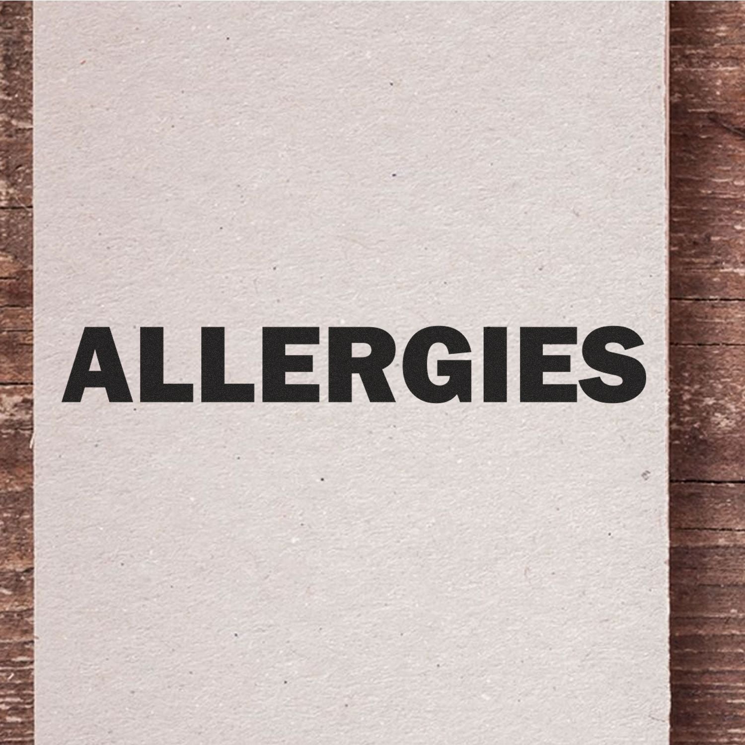 Large Pre-Inked Bold Allergies Stamp imprint on white paper, displaying the word 'ALLERGIES' in bold black letters on a wooden surface.