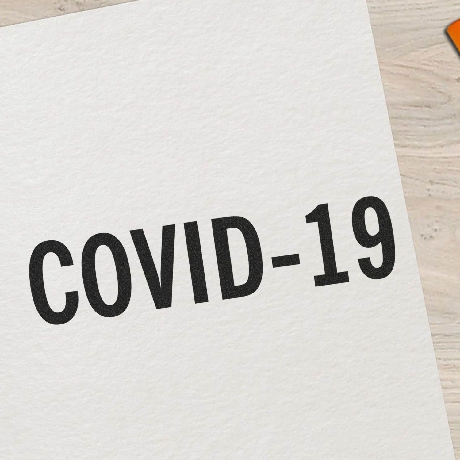 Bold Covid-19 Rubber Stamp on white paper, showcasing the clear and prominent COVID-19 text in black ink.