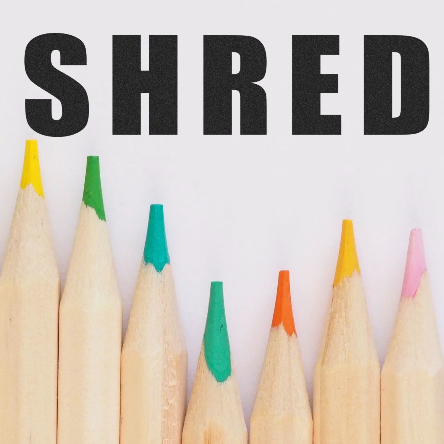 Colorful pencils beneath the Bold Shred Rubber Stamp imprinting the word SHRED in bold black letters on a white background.