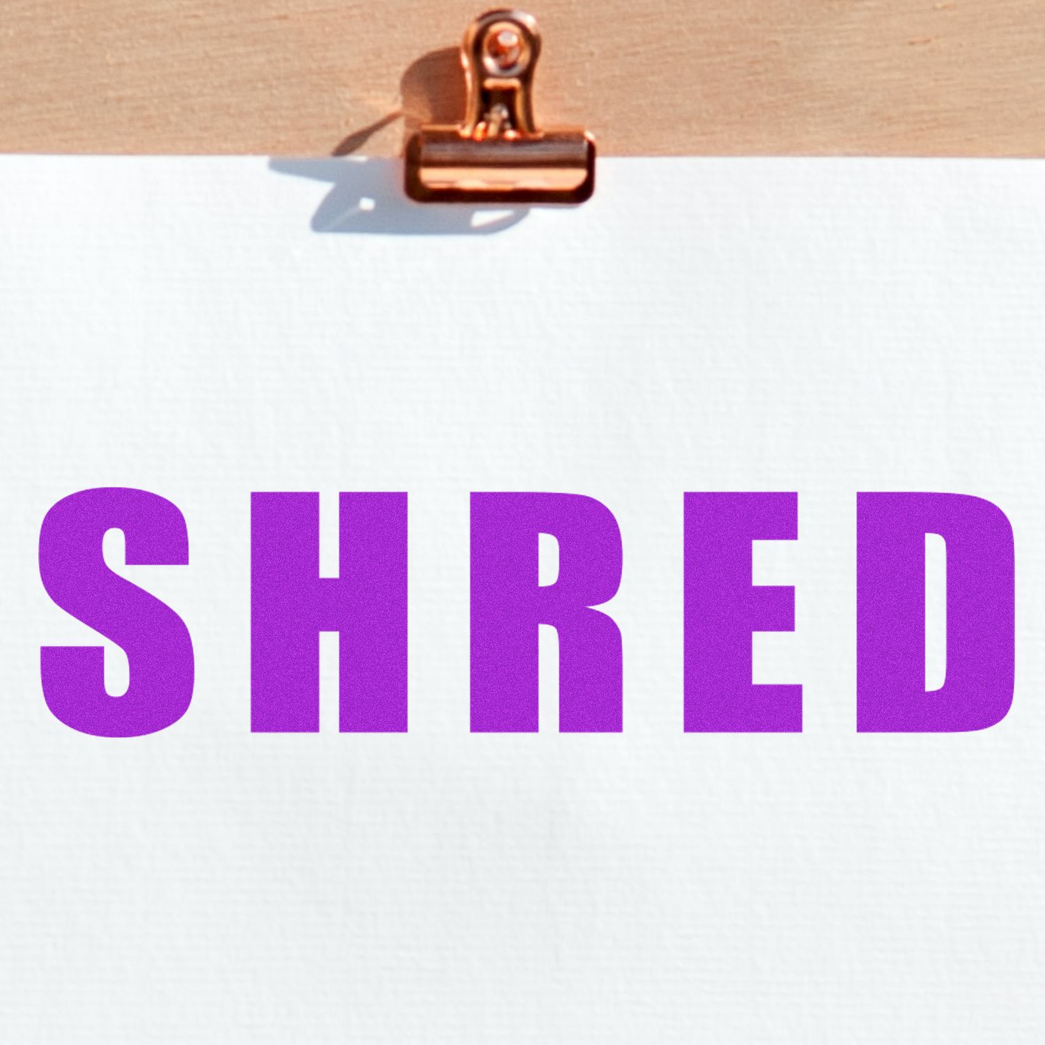 Bold Shred Rubber Stamp in use, displaying the word SHRED in bold purple letters on white paper clipped to a wooden board.