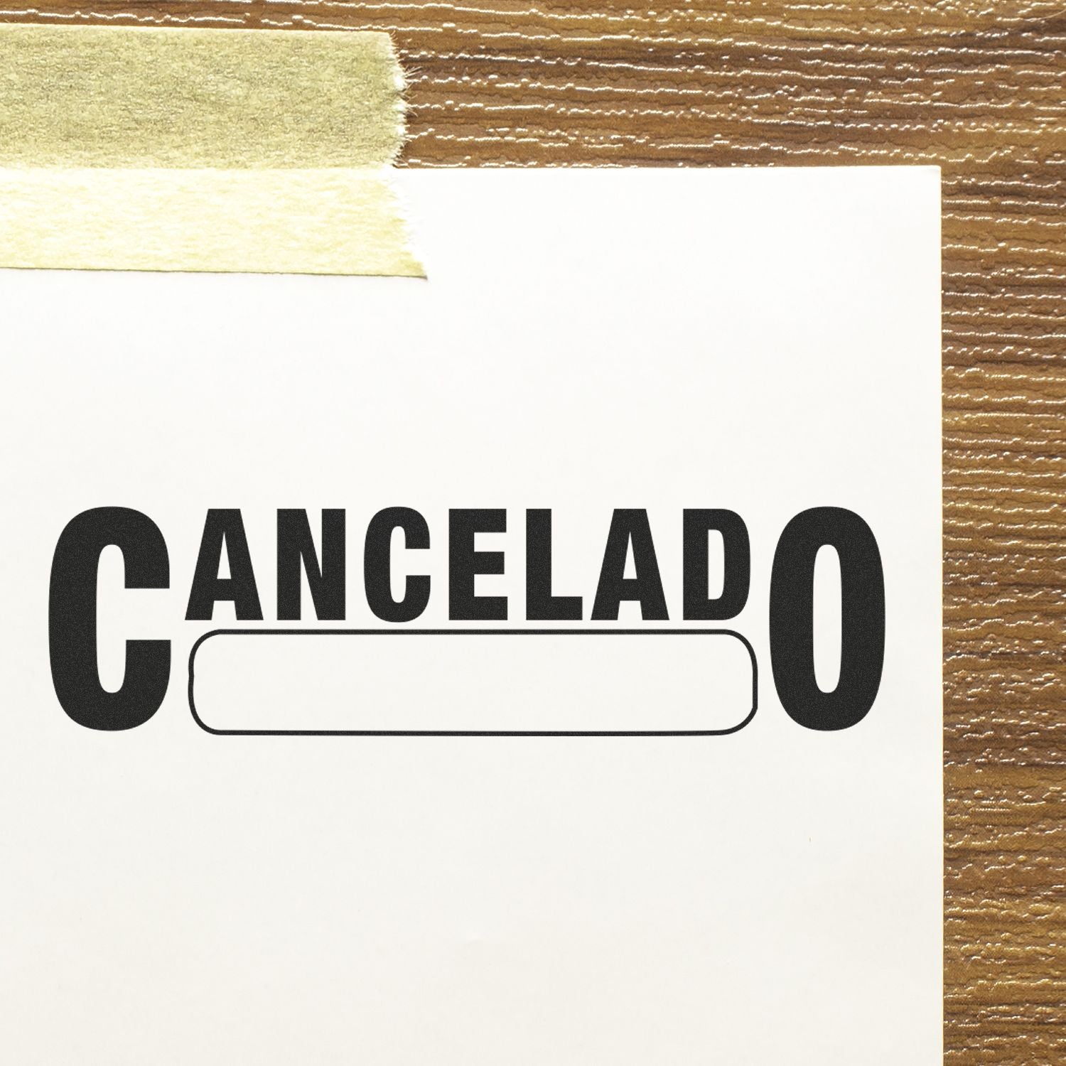 Cancelado with Box Rubber Stamp on white paper taped to a wooden surface, showing the stamped text 'CANCELADO' with a blank box underneath.