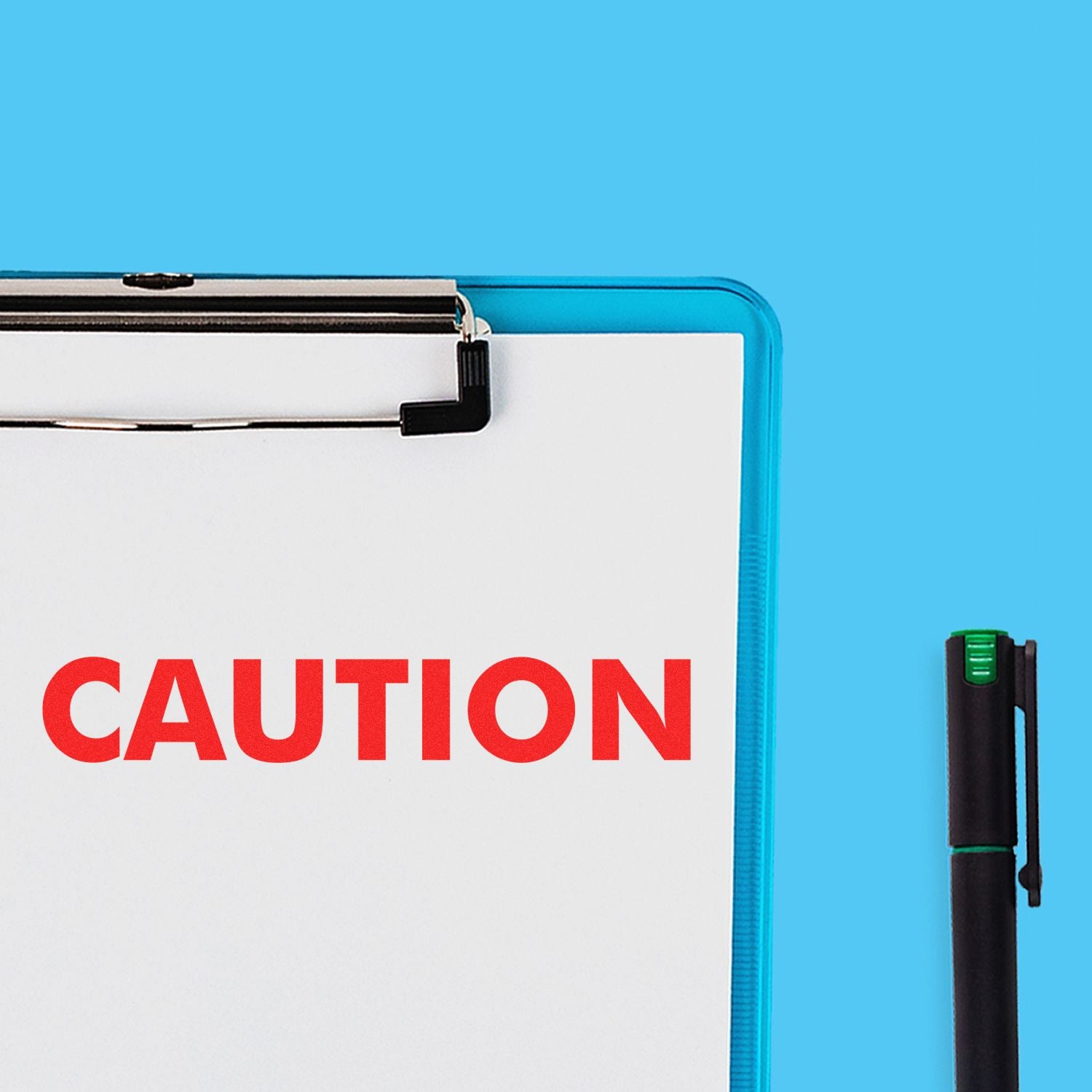 A clipboard with a paper stamped CAUTION in red using the Caution Rubber Stamp, next to a black pen on a blue background.