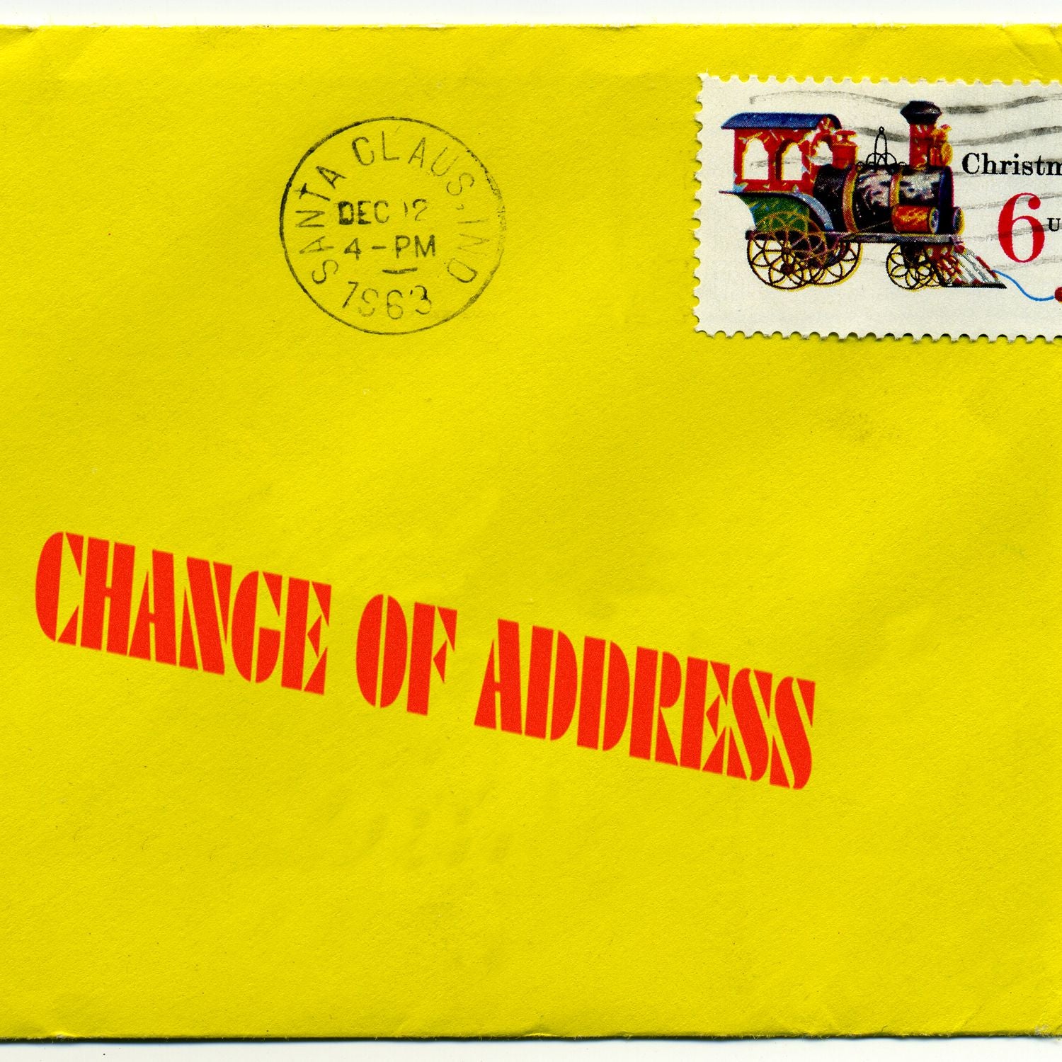 Yellow envelope stamped with CHANGE OF ADDRESS in red ink using the Large Pre-Inked Change Of Address Stamp, featuring a Christmas-themed postage stamp.