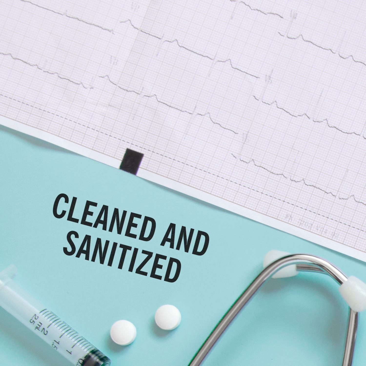 Cleaned and Sanitized rubber stamp on a blue surface with medical equipment, including a stethoscope, syringe, and pills.