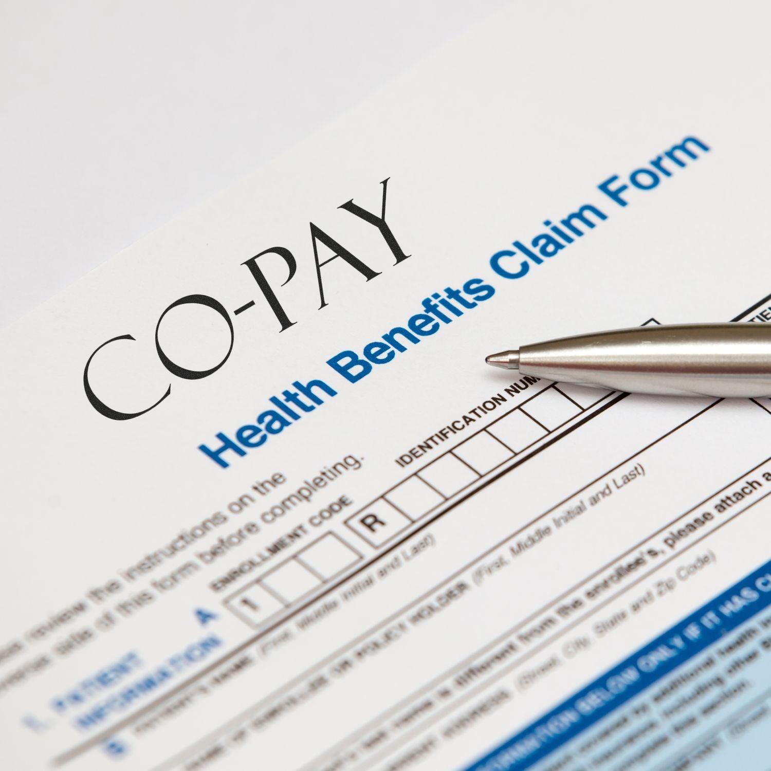 Close-up of a health benefits claim form stamped with CO-PAY using the Self Inking Co-Pay Stamp, with a pen placed on the form.