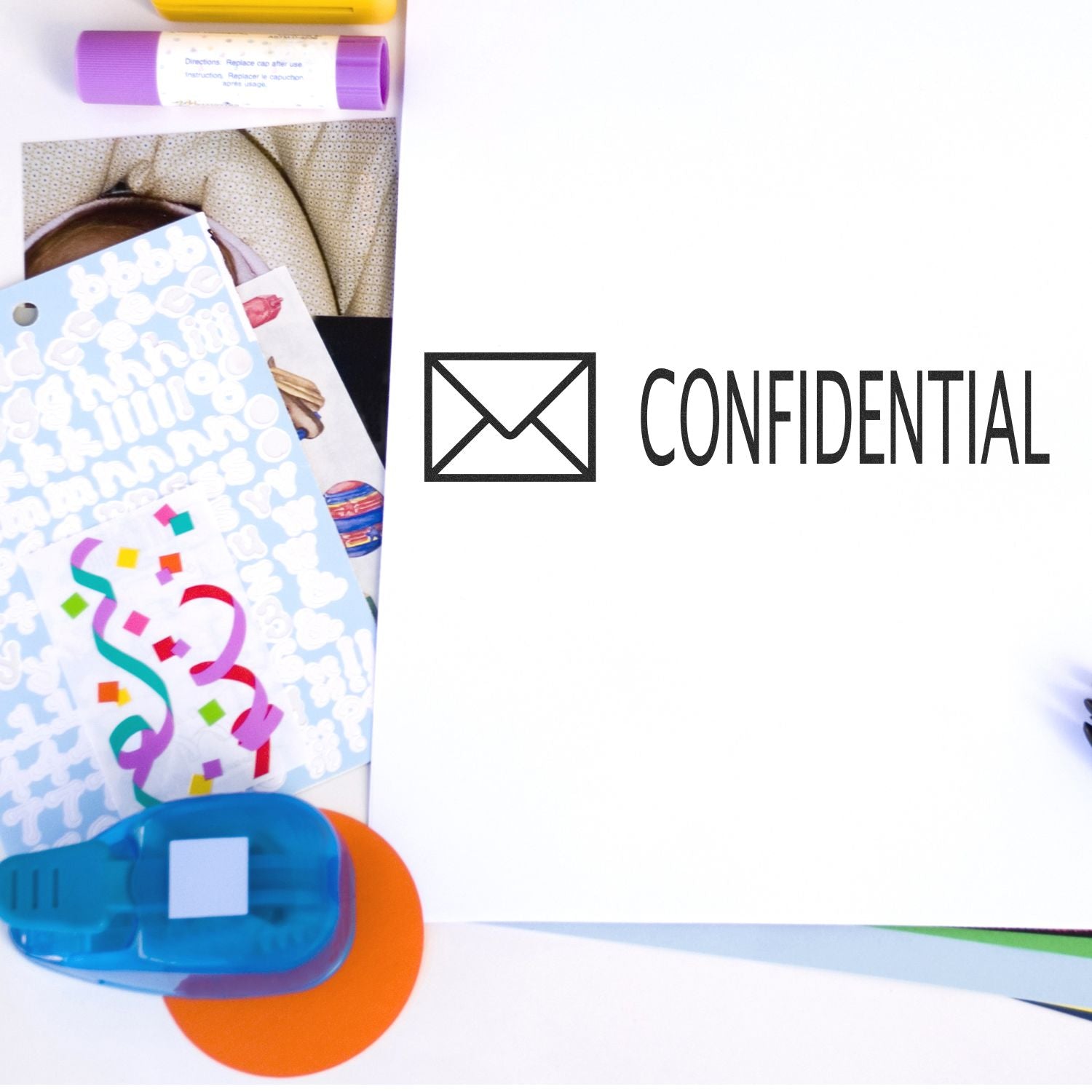 Large Pre-Inked Confidential with Envelope Stamp used on a white paper, surrounded by colorful stationery items.