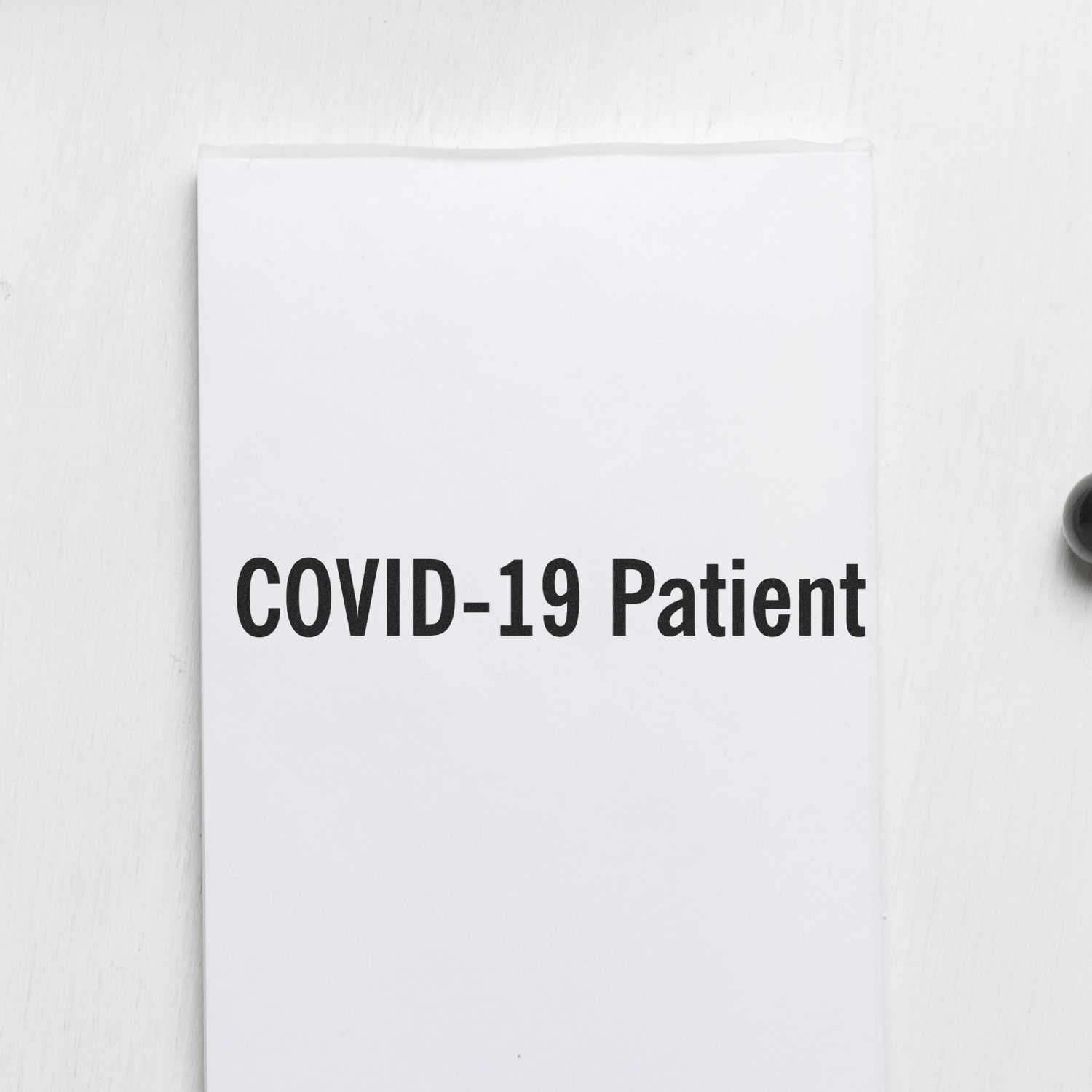 COVID-19 Patient rubber stamp on a white surface, partially visible black ink pad on the right.