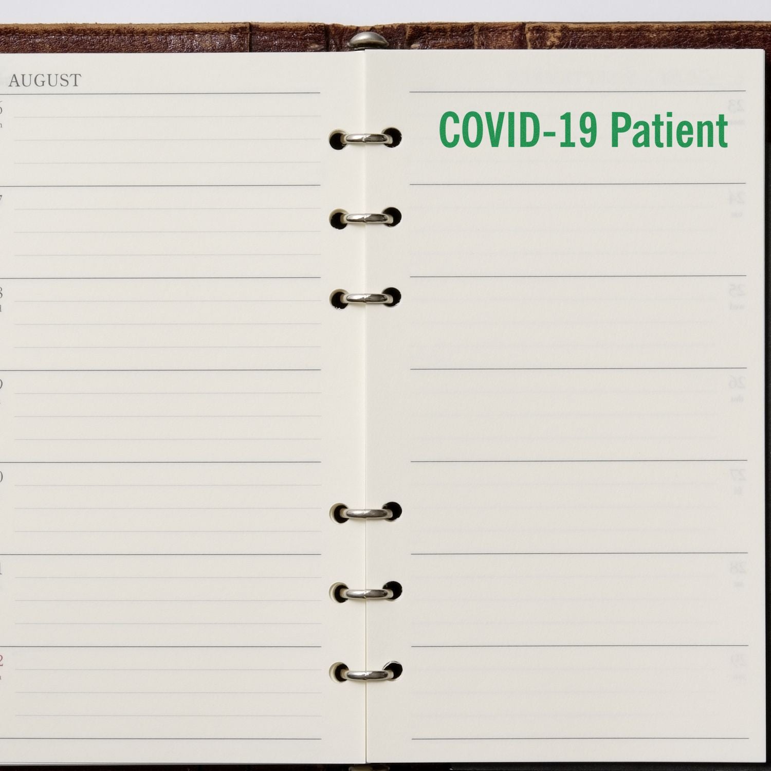 Open planner with COVID-19 Patient rubber stamp in green ink on the right page, indicating a scheduled entry.