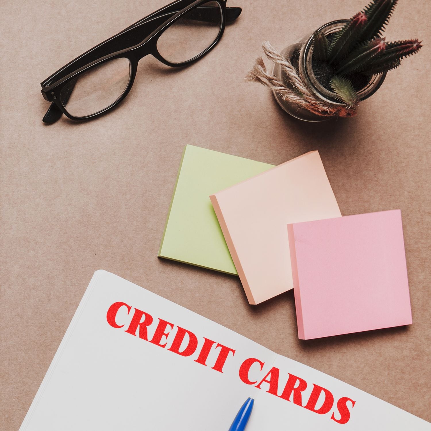 Credit Cards Rubber Stamp in use on a document, with glasses, sticky notes, a pen, and a small potted plant on a desk.