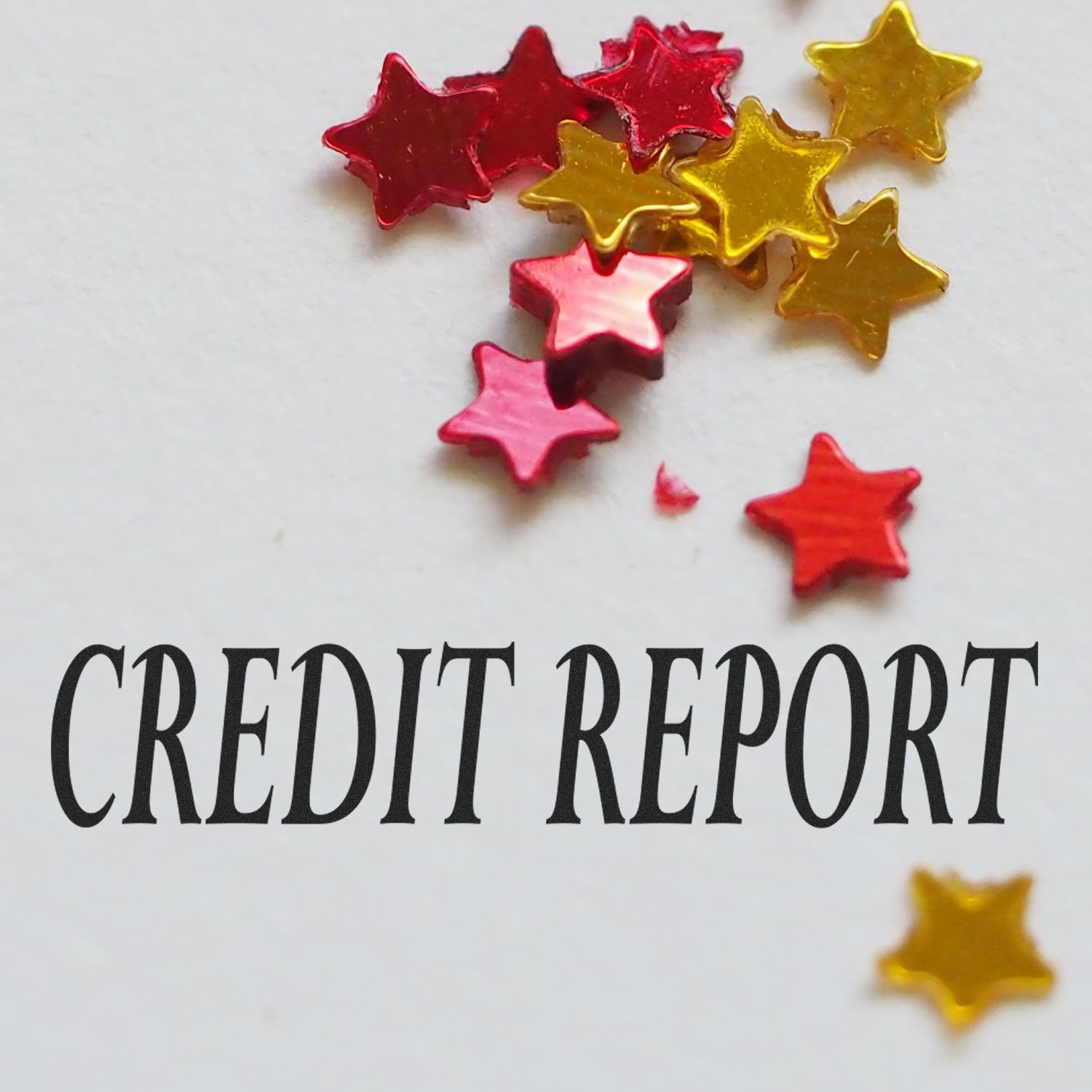 Credit Report Rubber Stamp on paper with scattered red and gold star-shaped confetti.