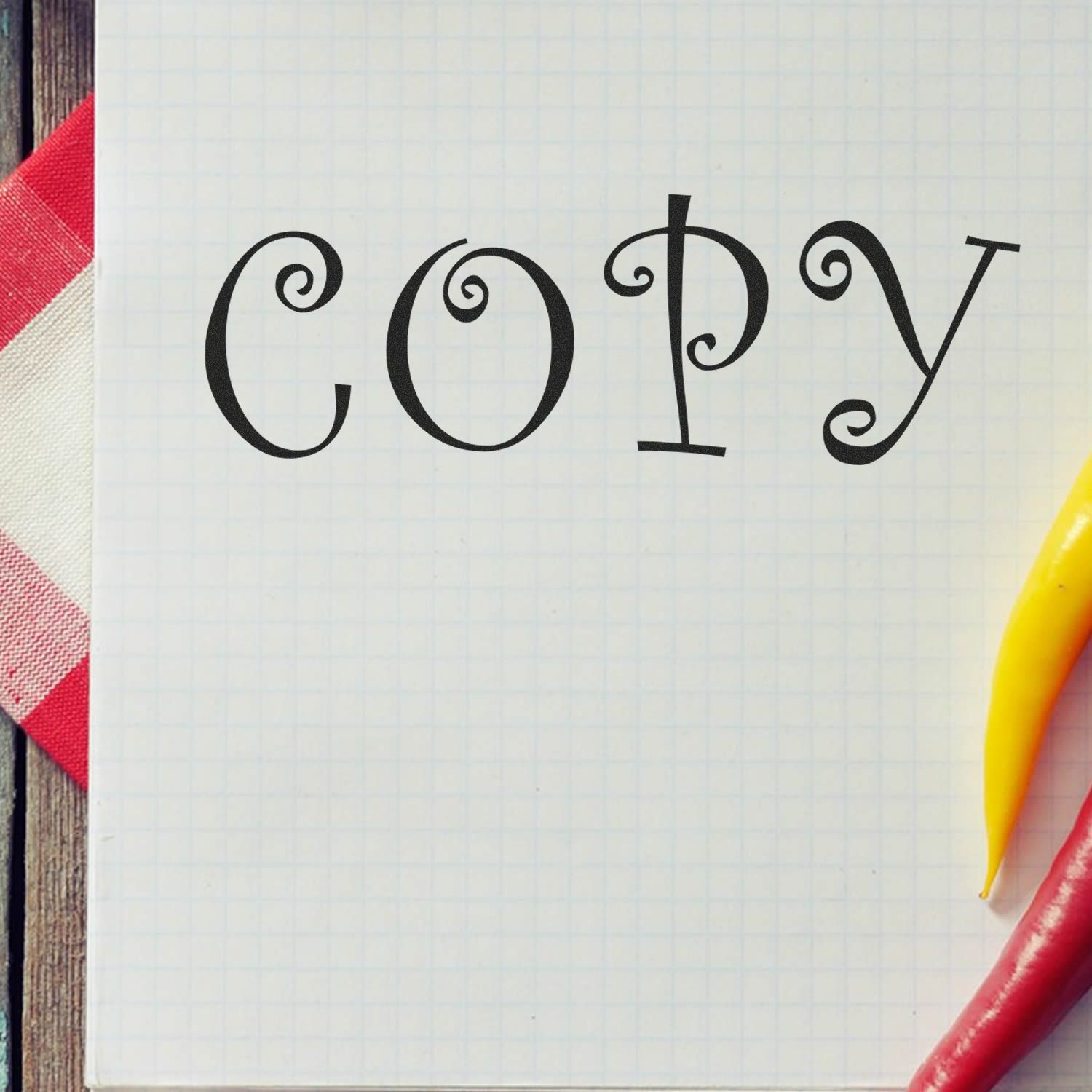 Large Self Inking Curly Copy Stamp used on graph paper, creating a whimsical 'COPY' text. Red and yellow peppers on the side.