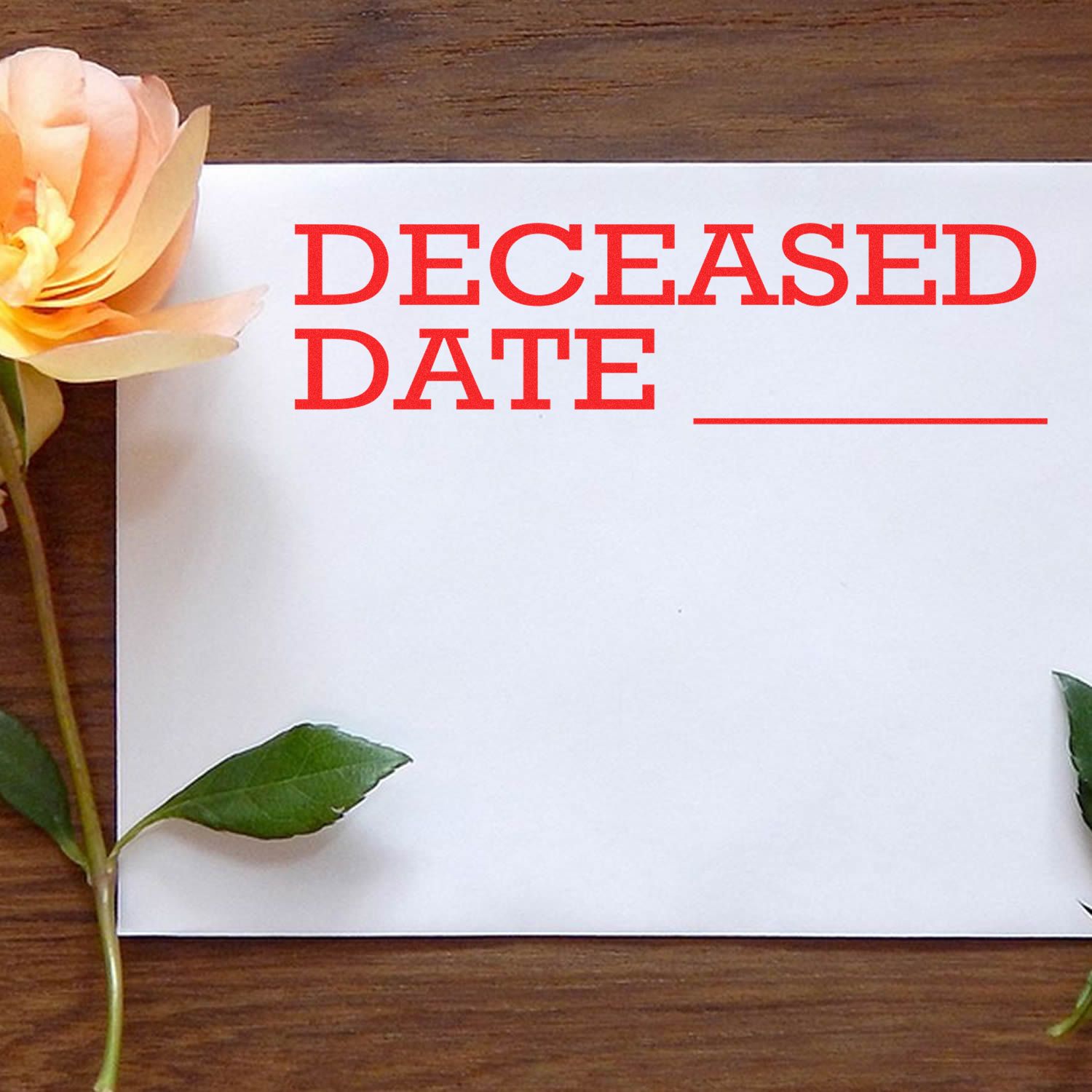 A Deceased Date Rubber Stamp imprint on a white paper with a blank line for the date, surrounded by a yellow rose and green leaves.