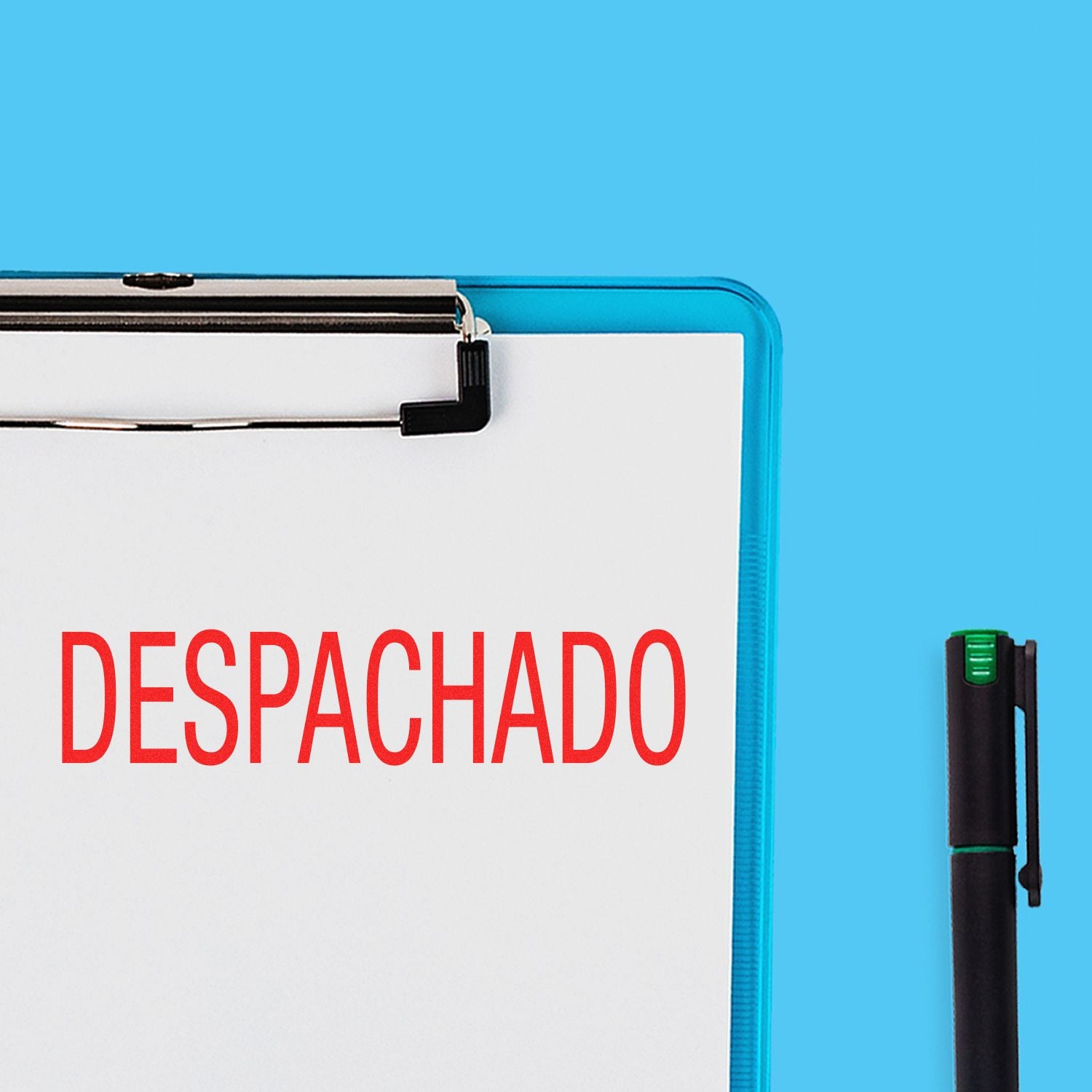 Clipboard with a paper stamped DESPACHADO in red using the Despachado Rubber Stamp, next to a black pen on a blue background.