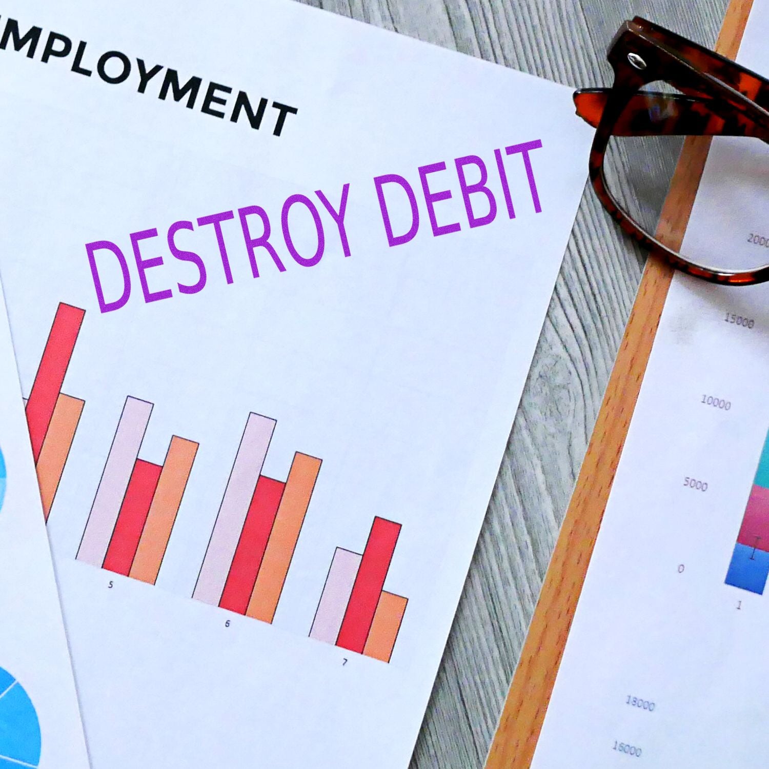 A document stamped with DESTROY DEBIT using the Self Inking Destroy Debit Stamp, placed on a desk with charts and glasses.