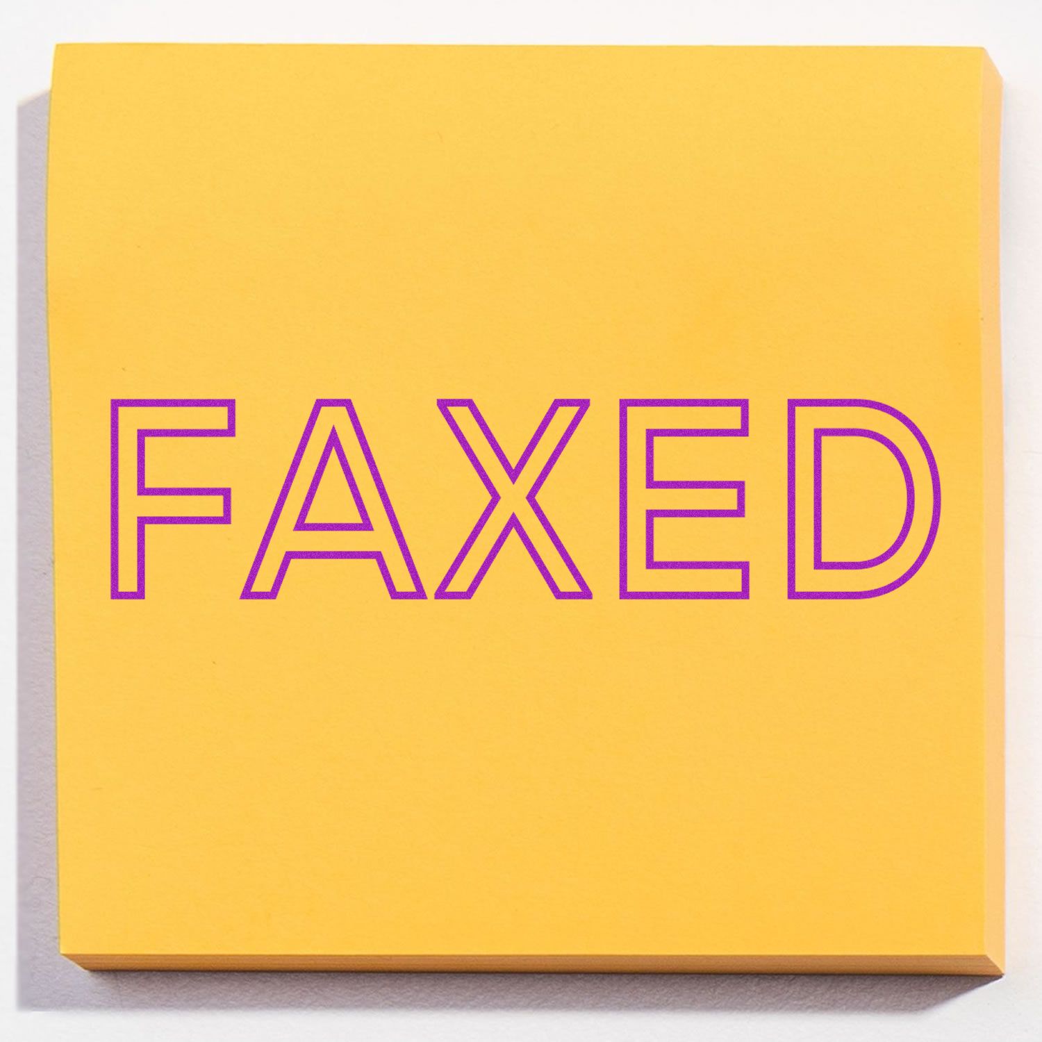 Yellow sticky note with the word FAXED stamped in purple using the Faxed Rubber Stamp.