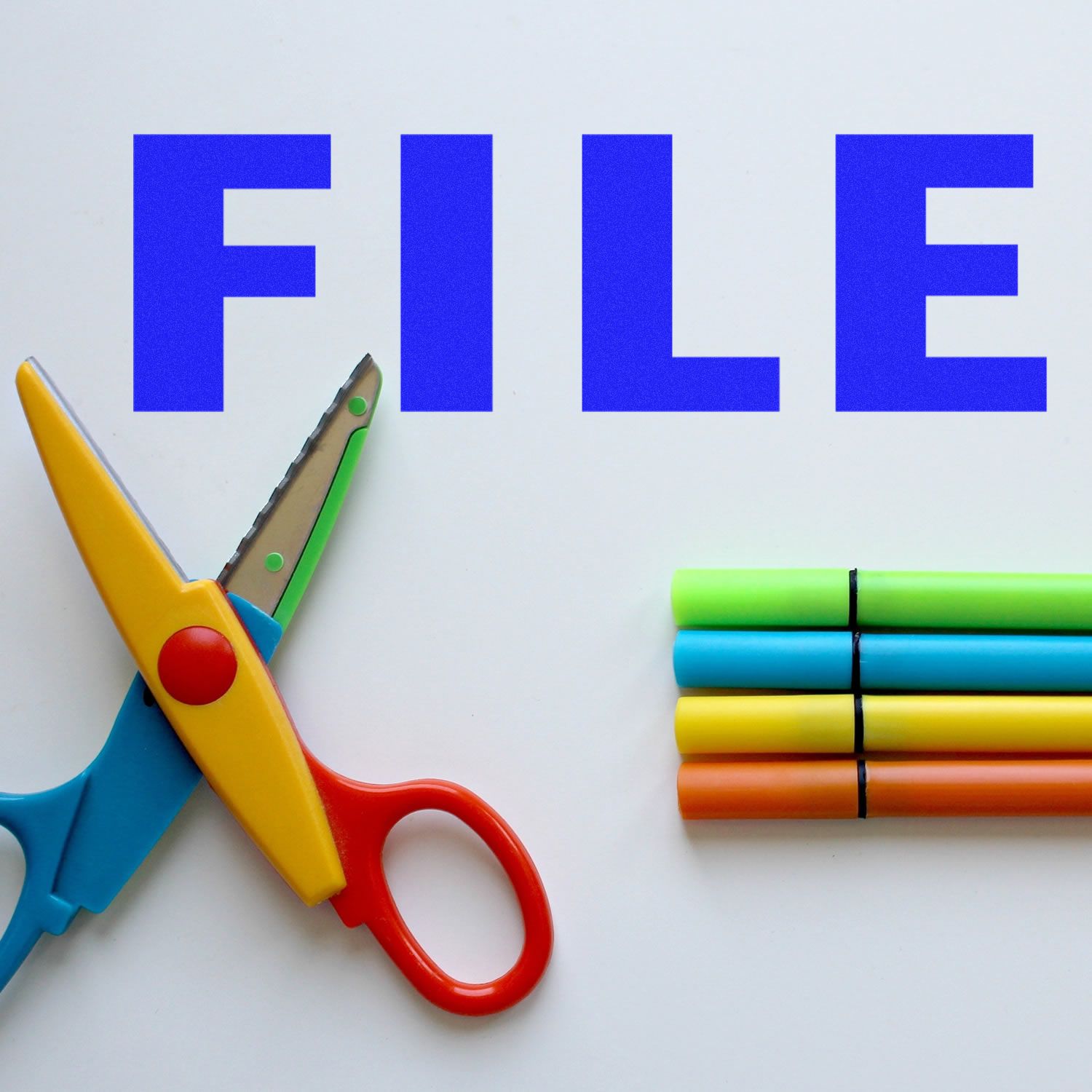 Large File Rubber Stamp in use, with colorful scissors and markers on a white surface. The word FILE is stamped in bold blue letters.