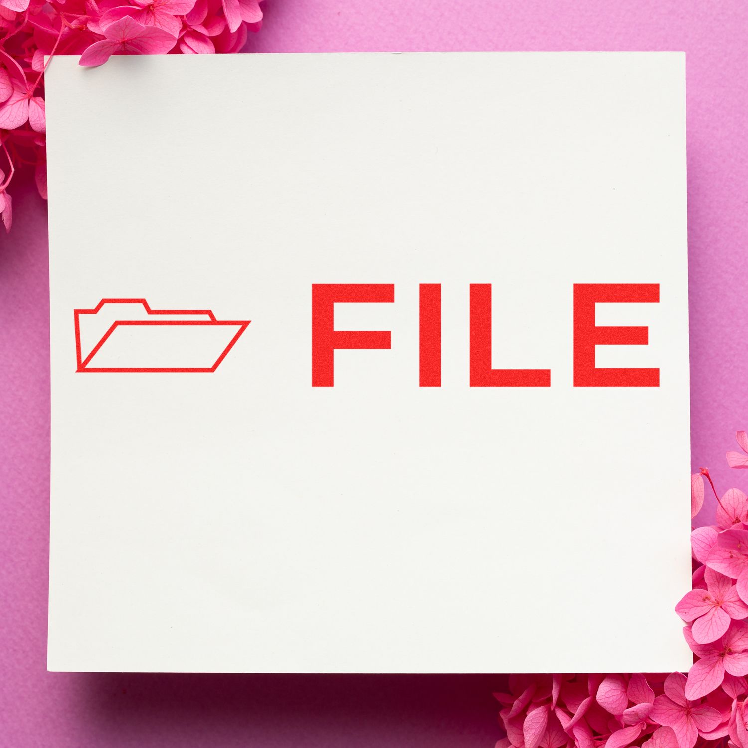 File with Folder Rubber Stamp in red ink on white paper, surrounded by pink flowers on a pink background.