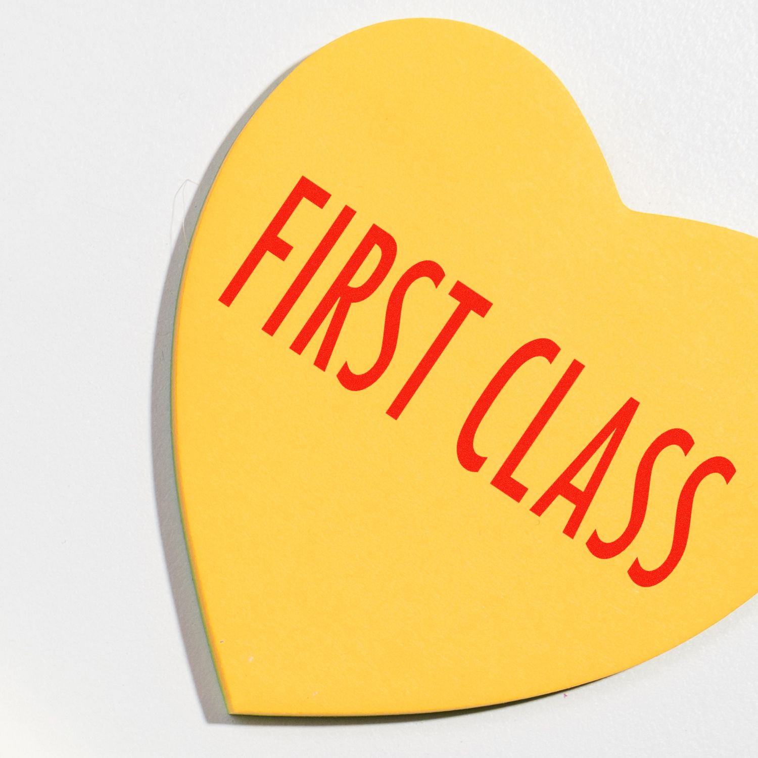 Yellow heart-shaped paper stamped with FIRST CLASS in red using the Large Self Inking First Class Stamp.