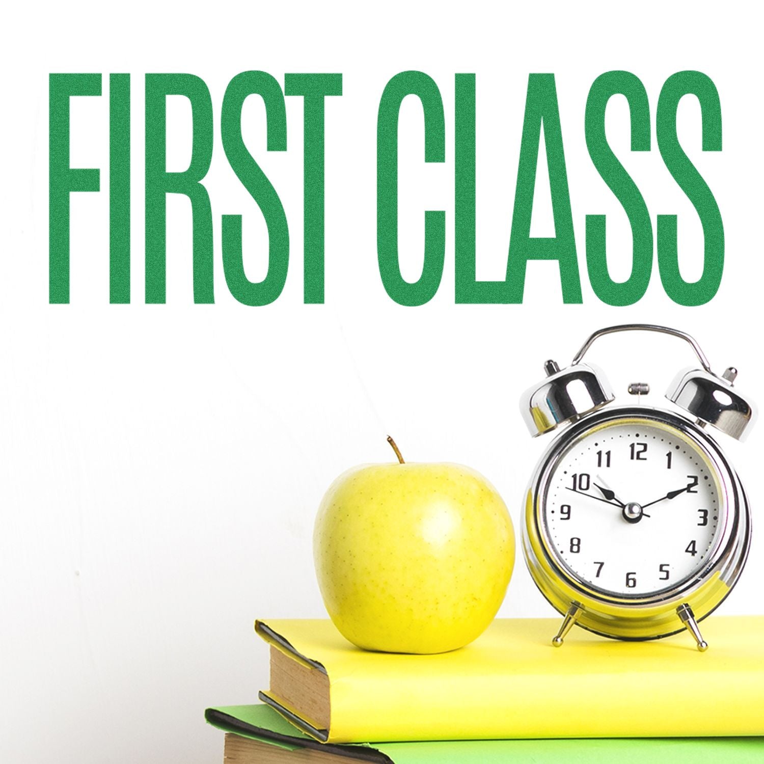 Large First Class Rubber Stamp in use, with FIRST CLASS stamped in green above a stack of books, an apple, and an alarm clock.