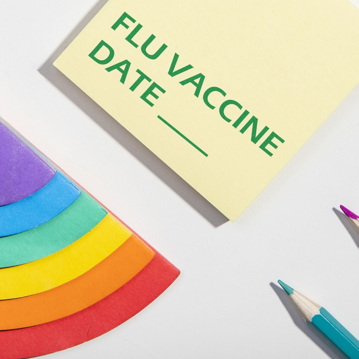 Flu Vaccine Date Rubber Stamp on a yellow card with colored pencils and rainbow paper nearby, ready for use.