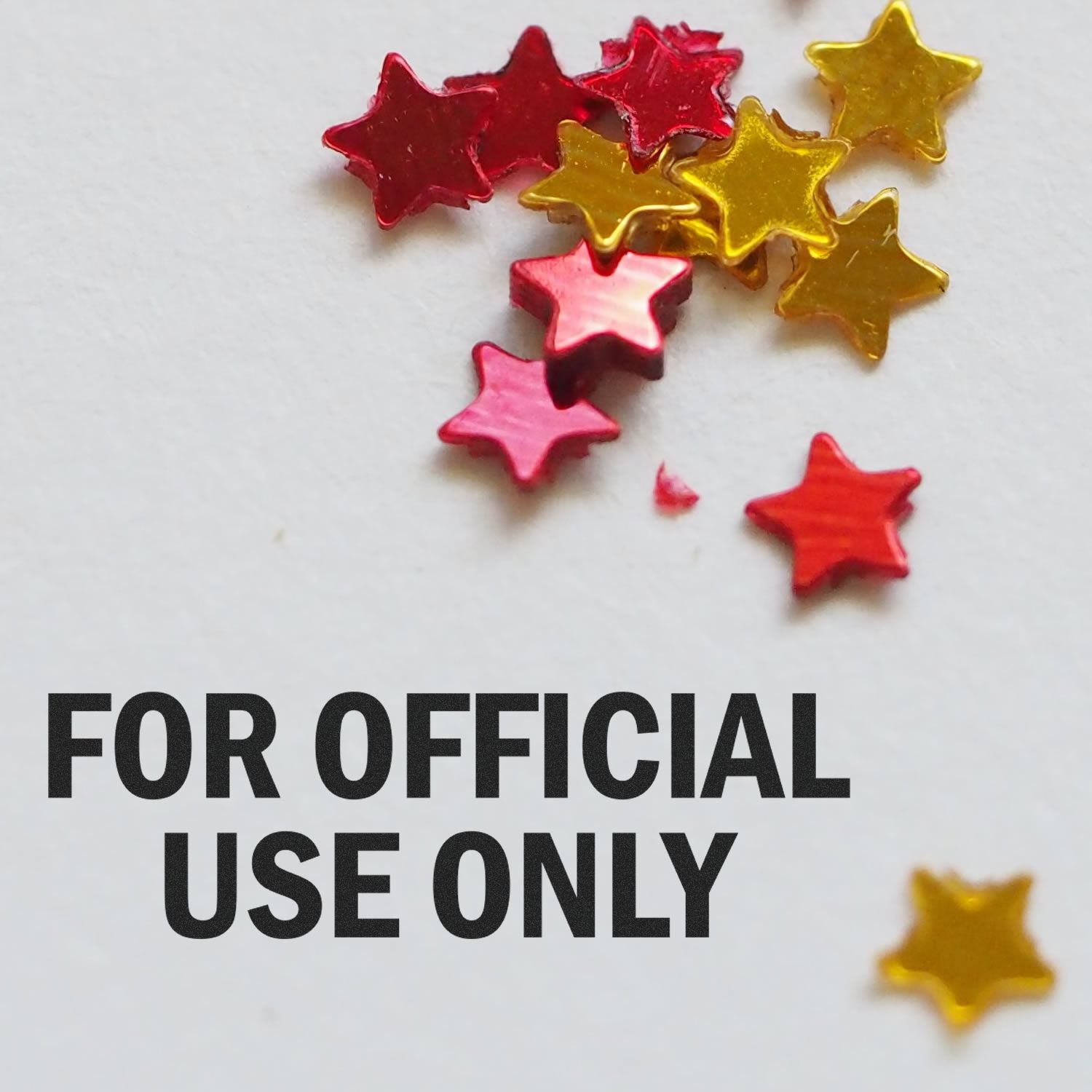 Large For Official Use Only Rubber Stamp imprint on white paper with scattered red and gold star-shaped confetti.