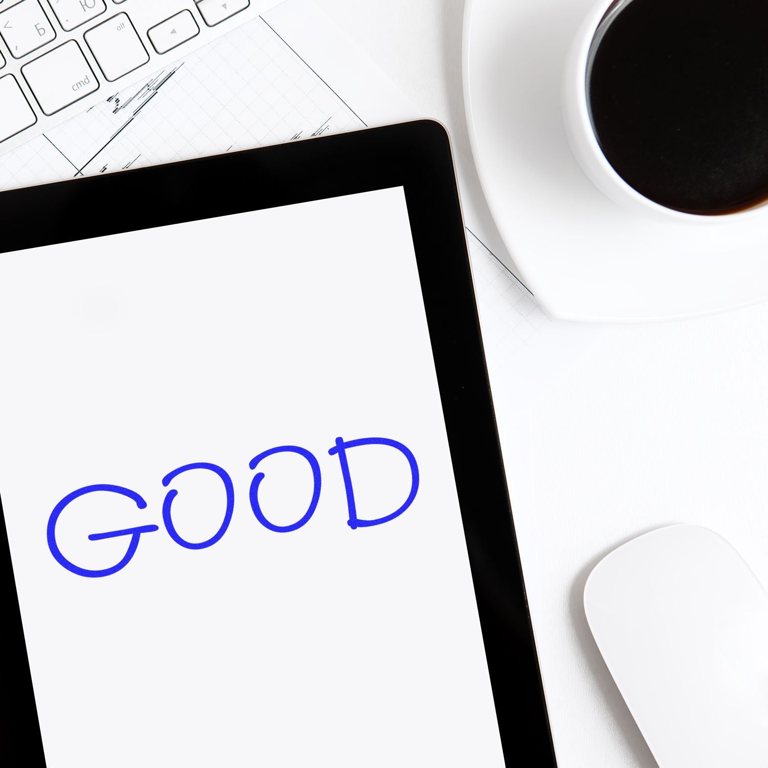 Large Pre-Inked Good Stamp in use, stamping the word GOOD on a white paper, with a keyboard, tablet, mouse, and coffee cup nearby.