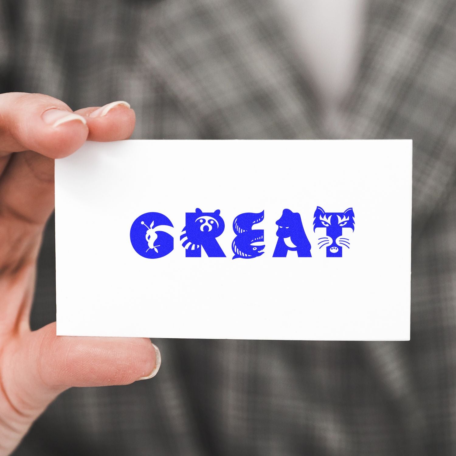 Hand holding a white card stamped with the word GREAT in blue ink using the Large Self Inking Great Stamp, featuring animal-themed letters.