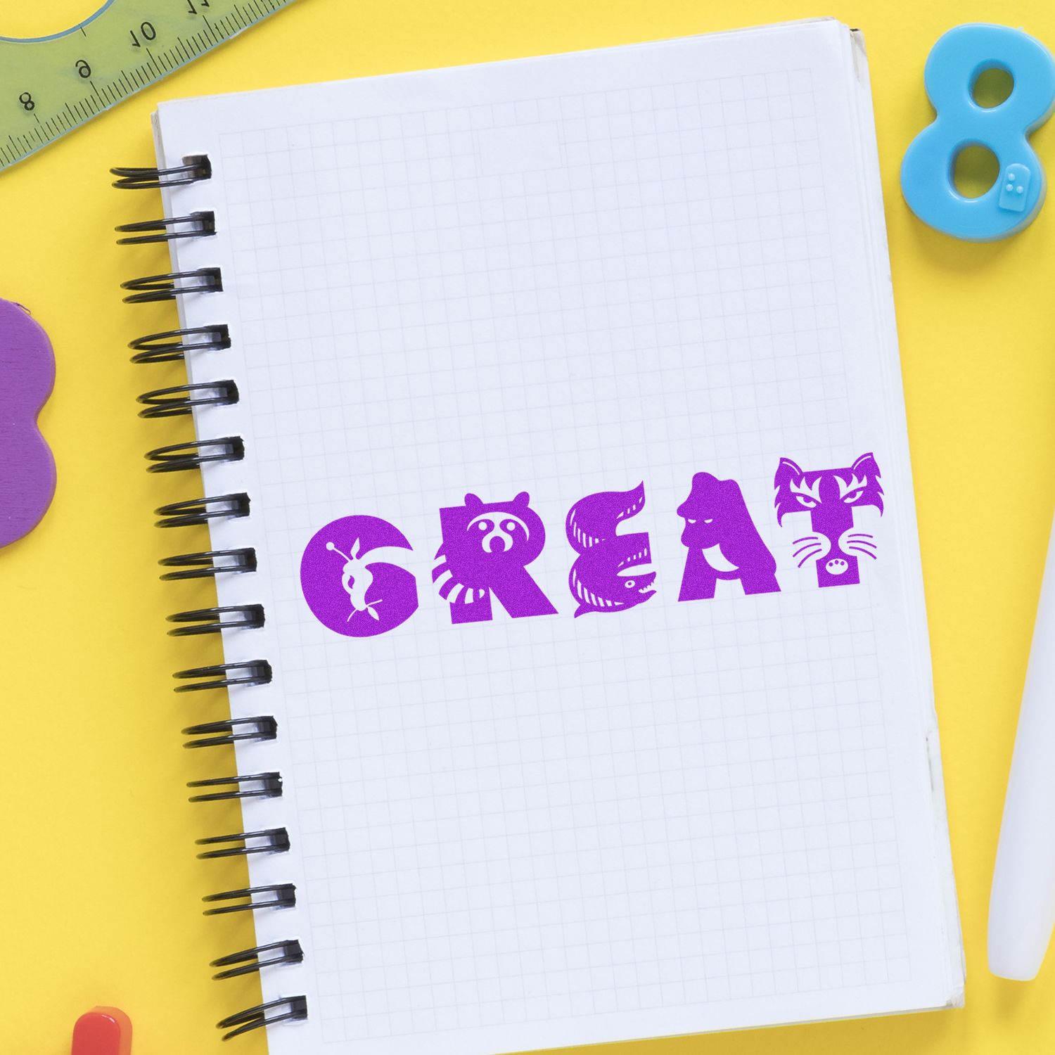 A notebook with a grid pattern features the word GREAT stamped in purple using the Large Self Inking Great Stamp, surrounded by colorful stationery.