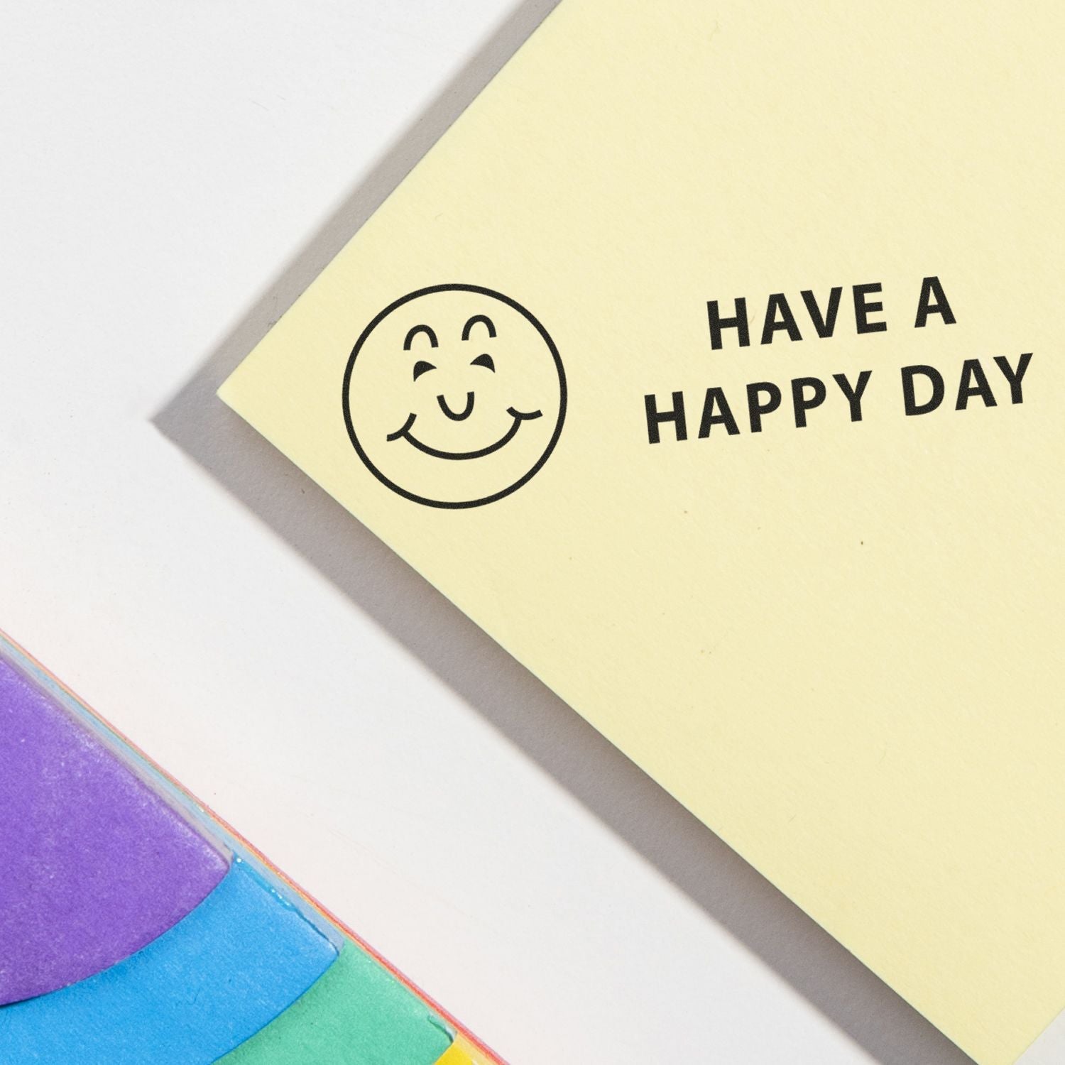 Yellow card stamped with Have a Happy Day and a smiley face using the Have a Happy Day Rubber Stamp, next to colorful sticky notes.