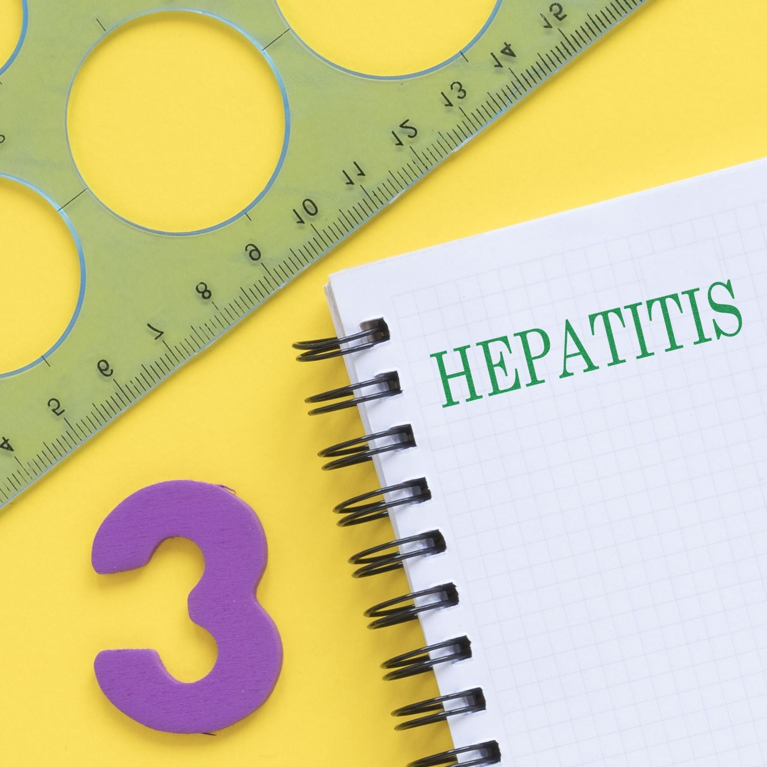 Self Inking Hepatitis Stamp used on a spiral notebook with the word HEPATITIS stamped in green, next to a ruler and a purple number 3.