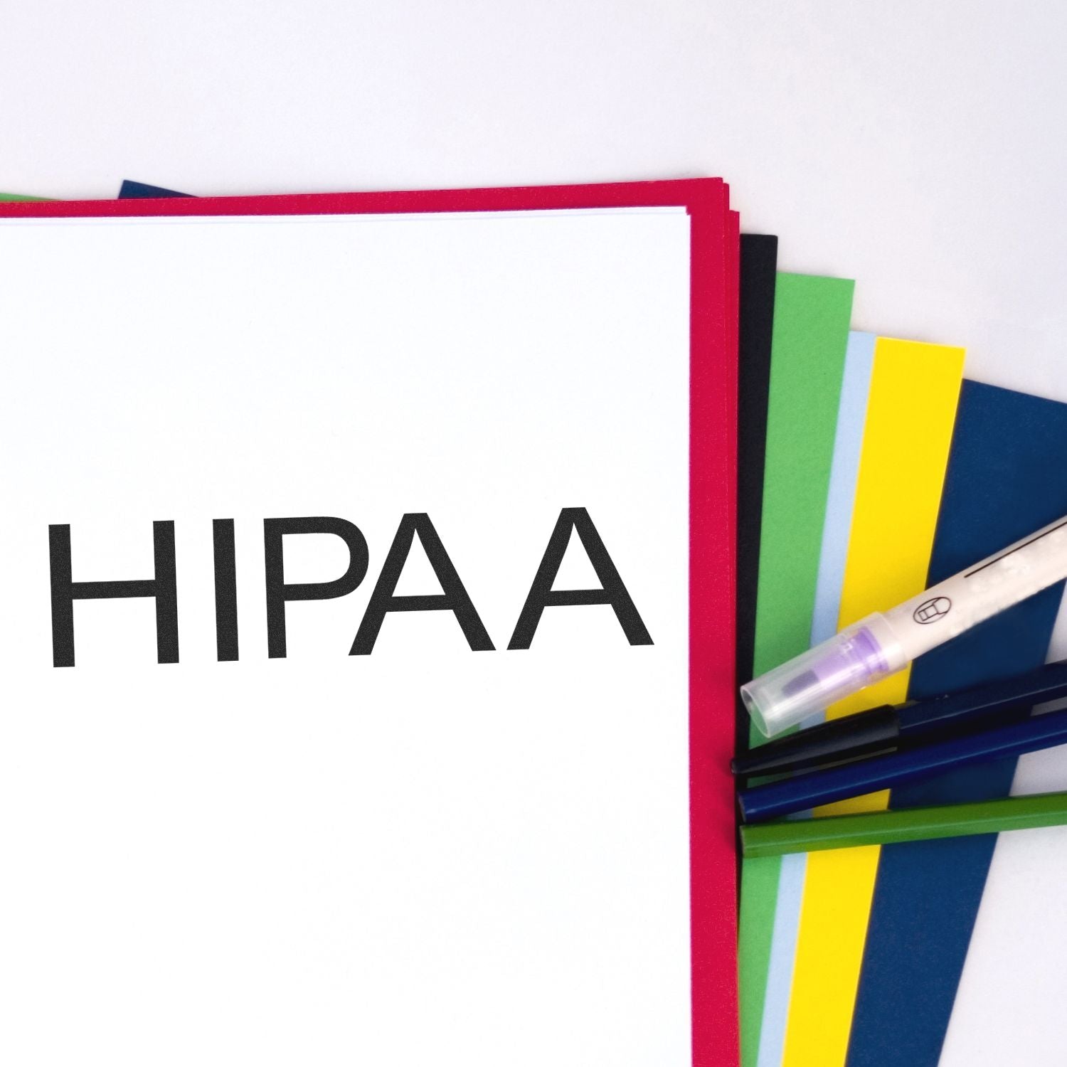 Hipaa Medical Rubber Stamp in use on a stack of colorful papers with pens and a highlighter nearby.