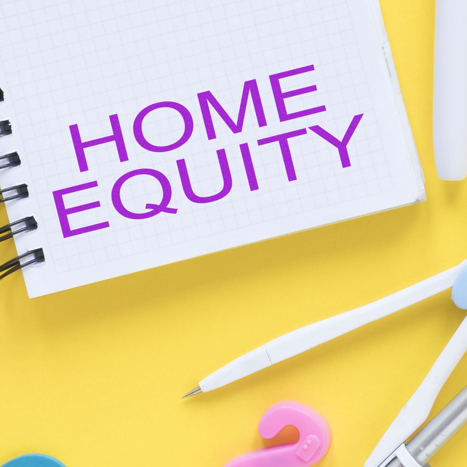 Home Equity Rubber Stamp used on a notebook with the words HOME EQUITY in purple, surrounded by office supplies on a yellow background.