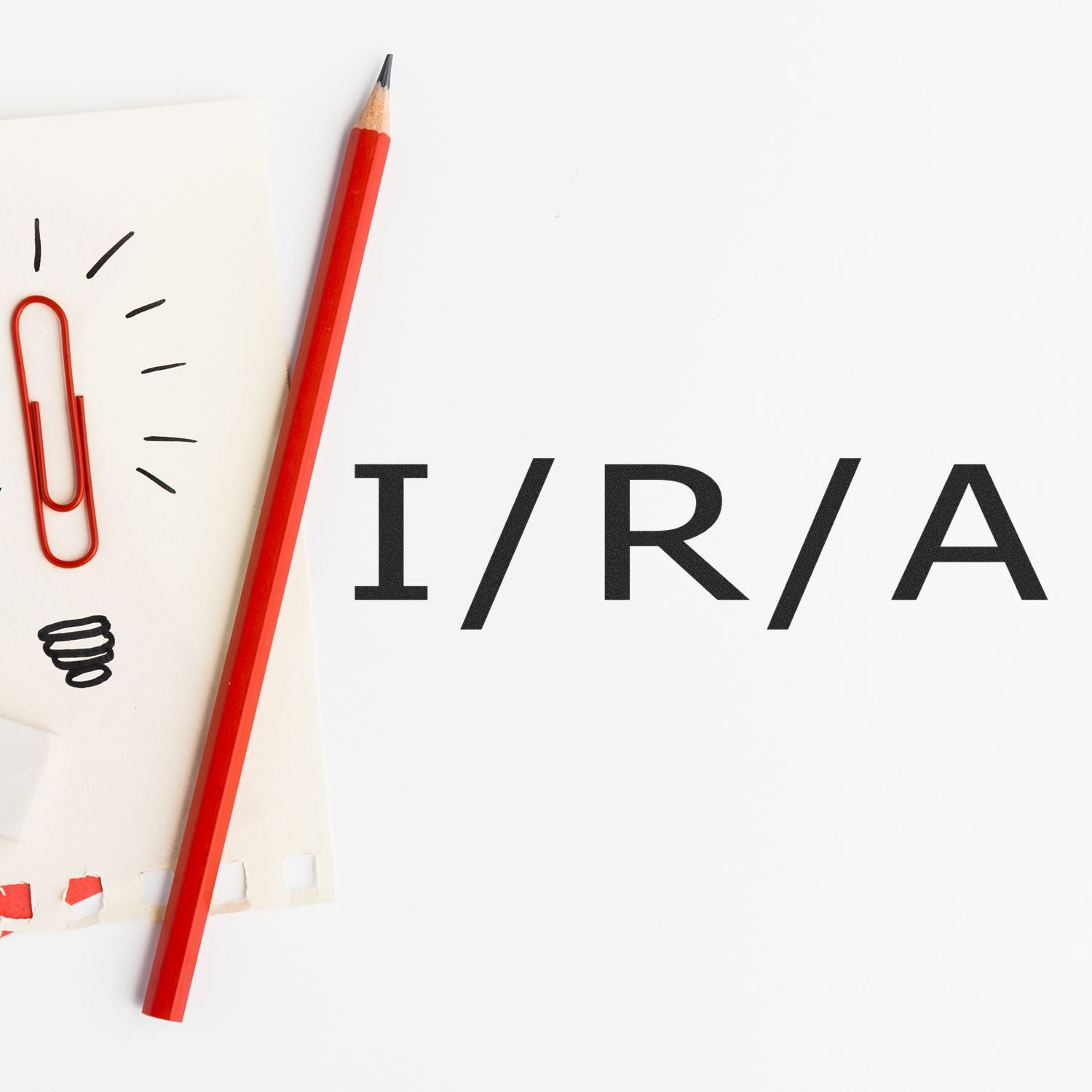 Red pencil and paperclip next to a stamped I/R/A text using the Large Self Inking I/R/A Stamp on white background.