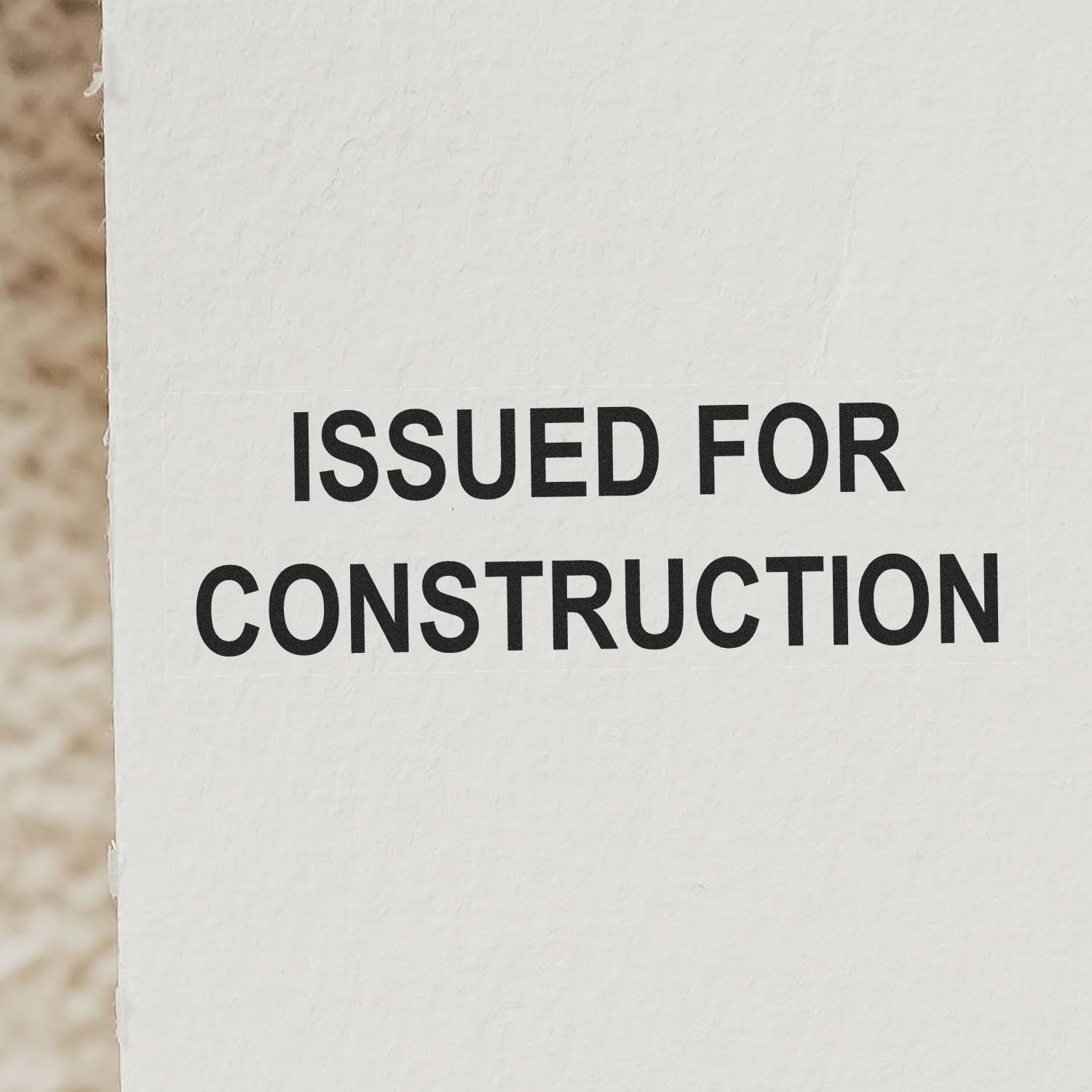 Close-up of a document stamped with 'Issued for Construction' using a Slim Pre-Inked Issued for Construction Stamp.