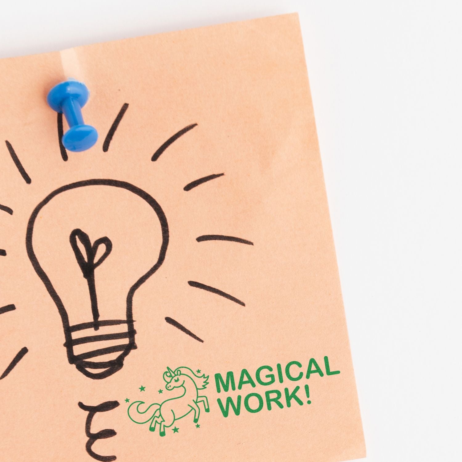 A sticky note with a lightbulb drawing and the Large Self Inking Magical Work Stamp in green, featuring a unicorn and the text MAGICAL WORK!