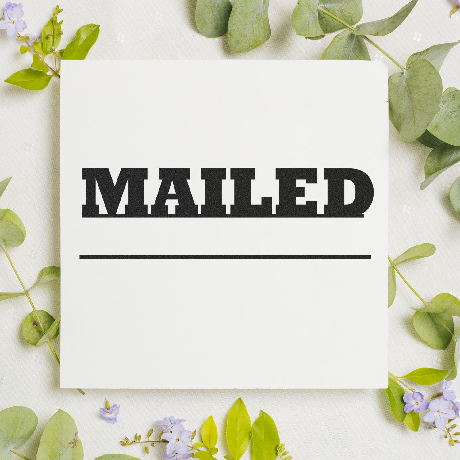 Large Mailed with Date Line Rubber Stamp on white paper surrounded by green leaves and small purple flowers.