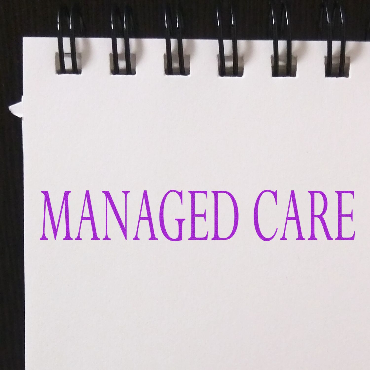 A white notepad with MANAGED CARE stamped in purple ink using a Slim Pre-Inked Managed Care Stamp.