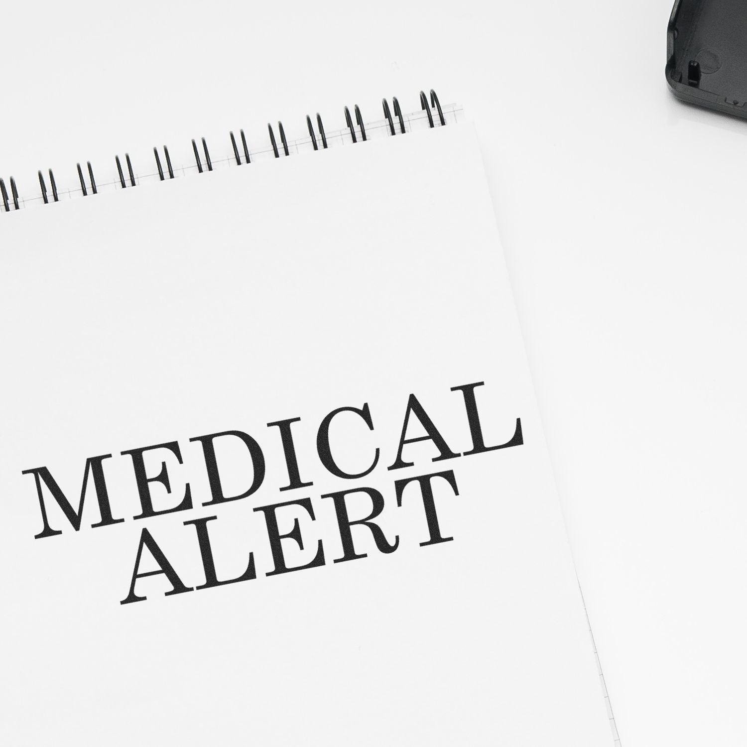 Large Medical Alert Rubber Stamp imprint on a white spiral notebook, emphasizing the words MEDICAL ALERT in bold black letters.