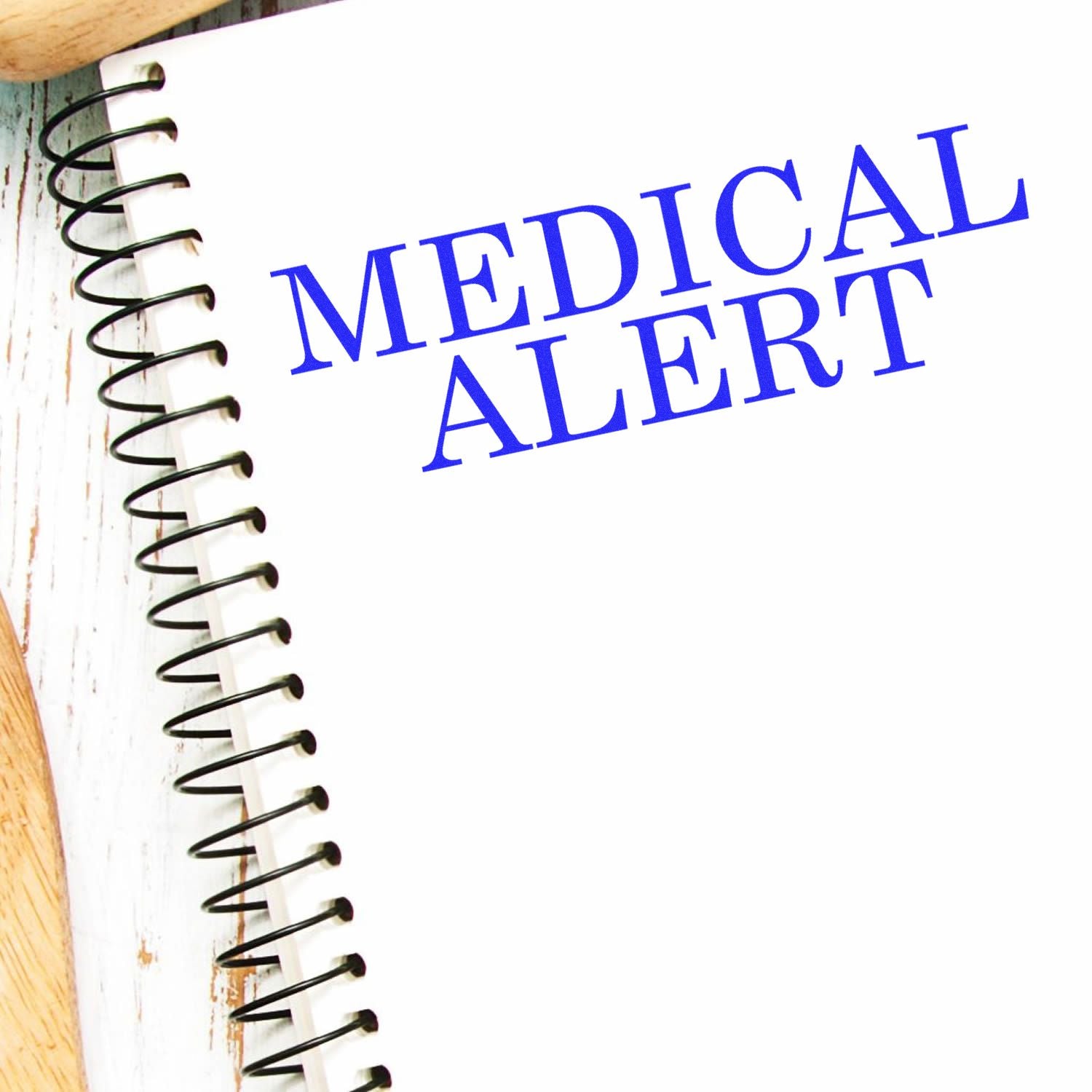 Large Pre-Inked Medical Alert Stamp used on a white spiral notebook, displaying the text MEDICAL ALERT in blue ink.