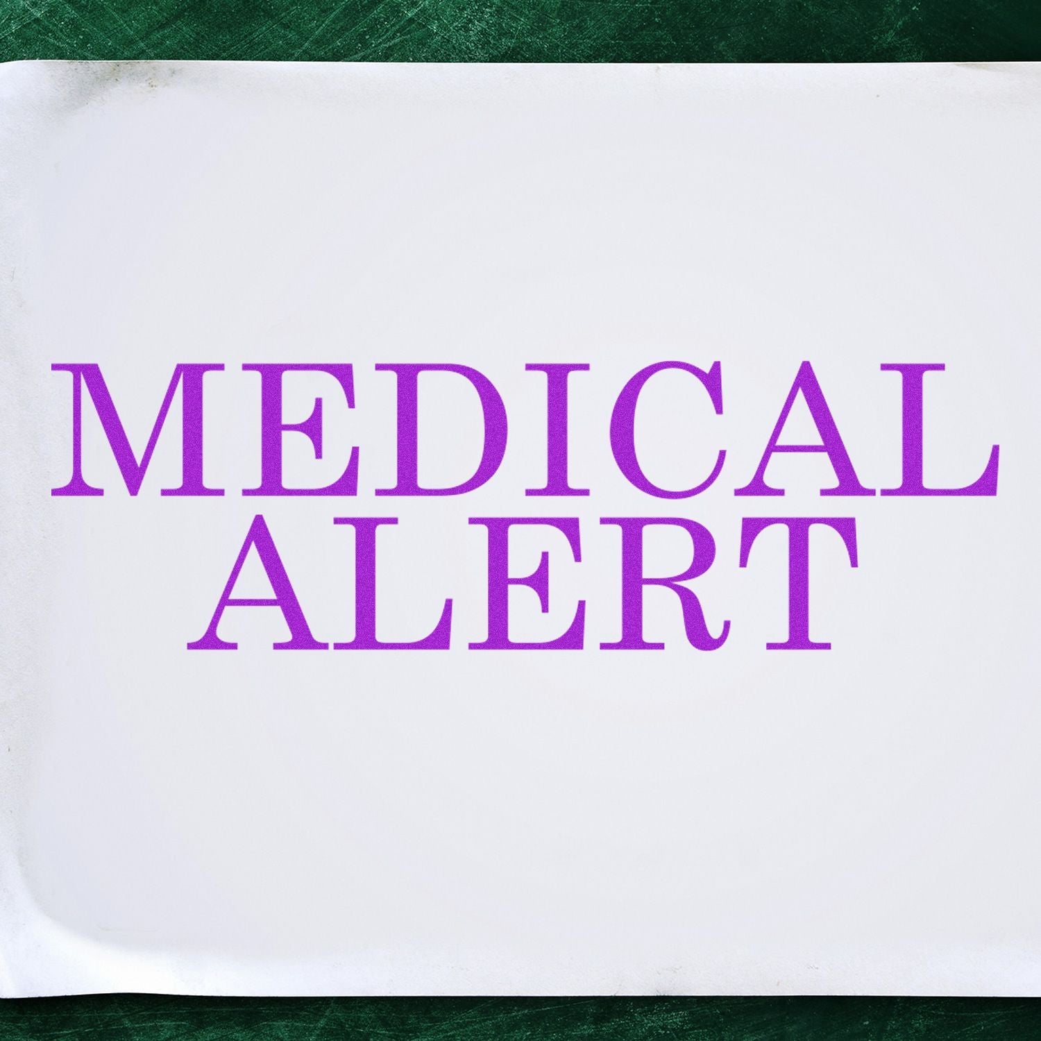 Self Inking Medical Alert Stamp imprinting MEDICAL ALERT in bold purple letters on white paper, placed on a green surface.