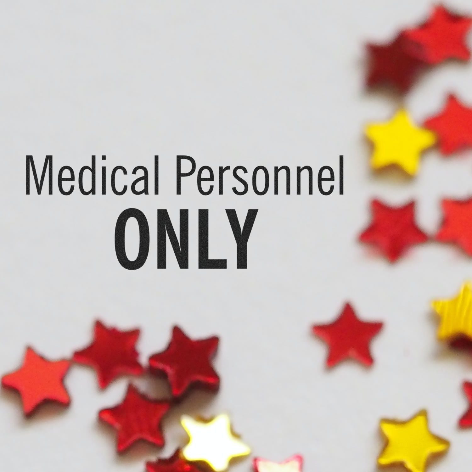 Large Pre-Inked Medical Personnel Only Stamp in use, with red and gold star confetti scattered around the stamped text on a white surface.