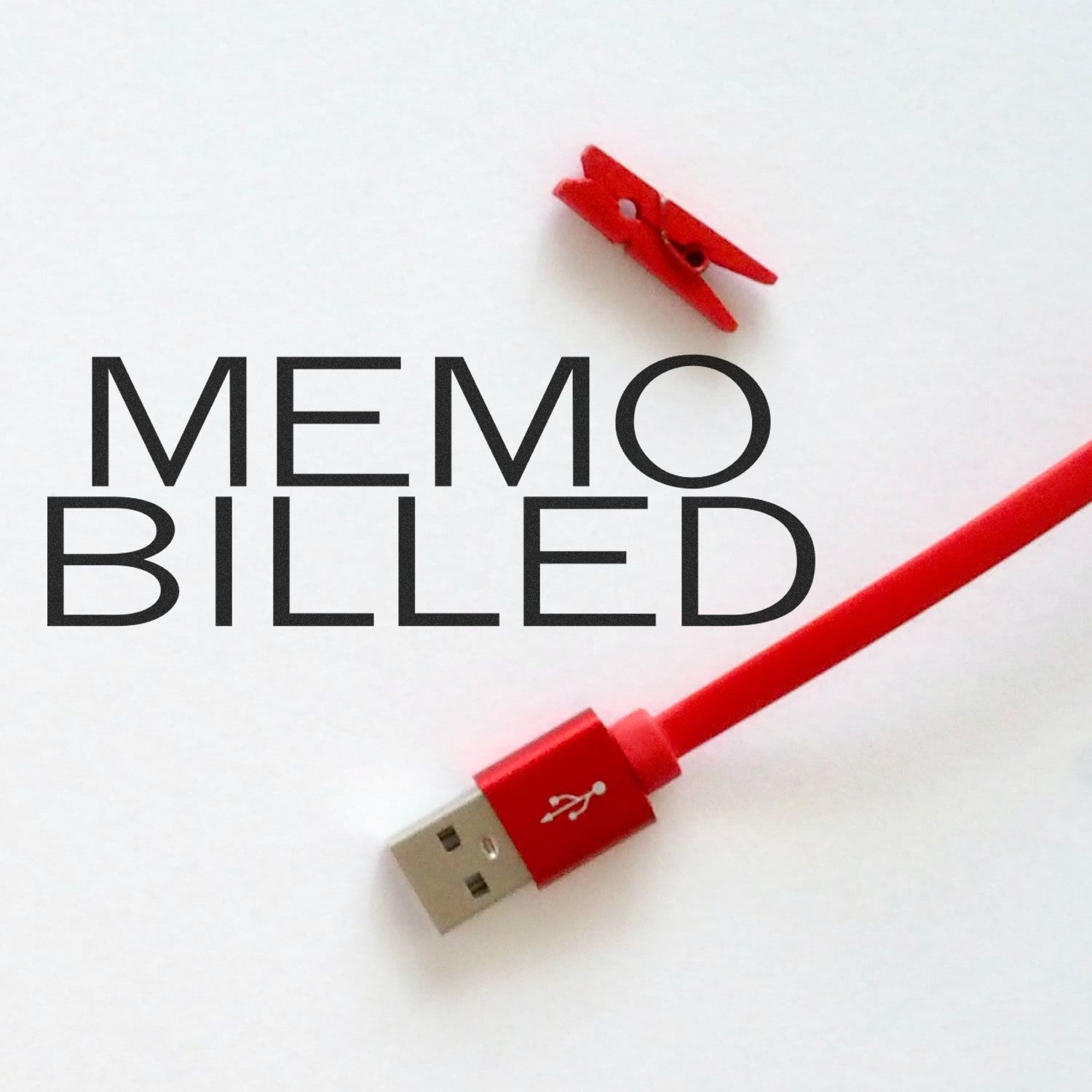 Large Self Inking Memo Billed Stamp in use, stamping MEMO BILLED on a white paper with a red USB cable and a small red clip nearby.