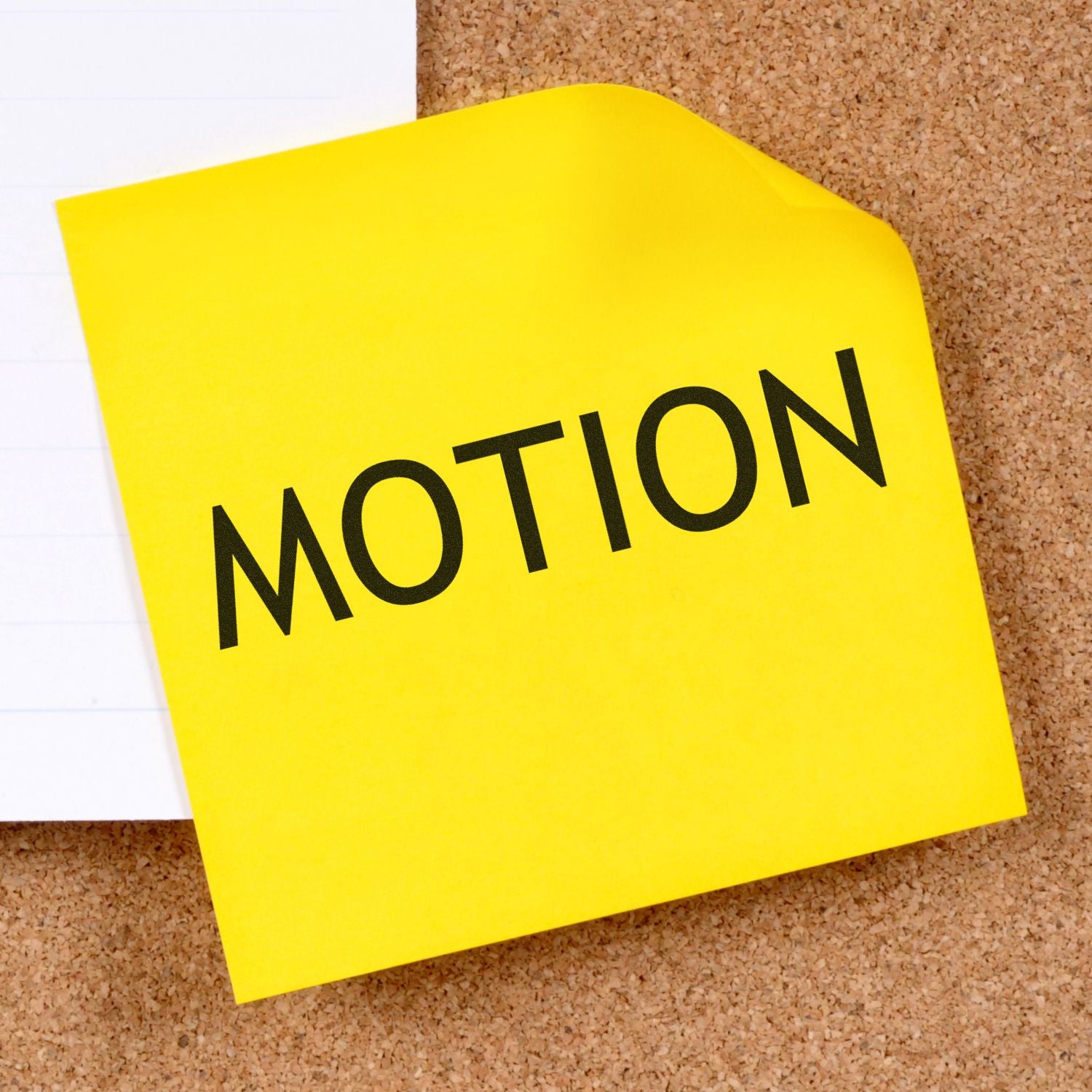 Yellow sticky note with the word MOTION stamped on it, pinned to a corkboard. Focus word: Lawyer Motion Rubber Stamp.