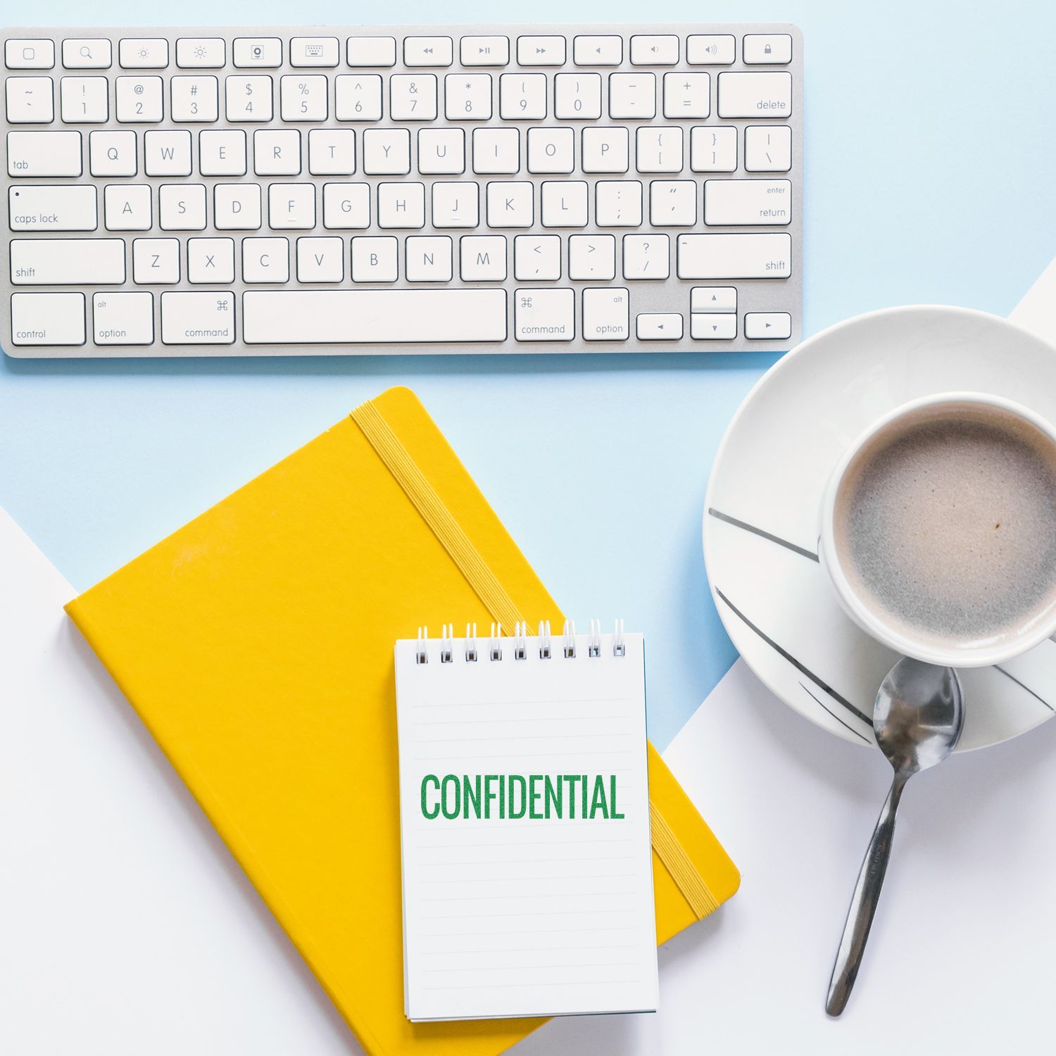 Yellow notebook, keyboard, coffee cup, and a notepad stamped CONFIDENTIAL using the Large Pre-Inked Narrow Confidential Stamp on a desk.